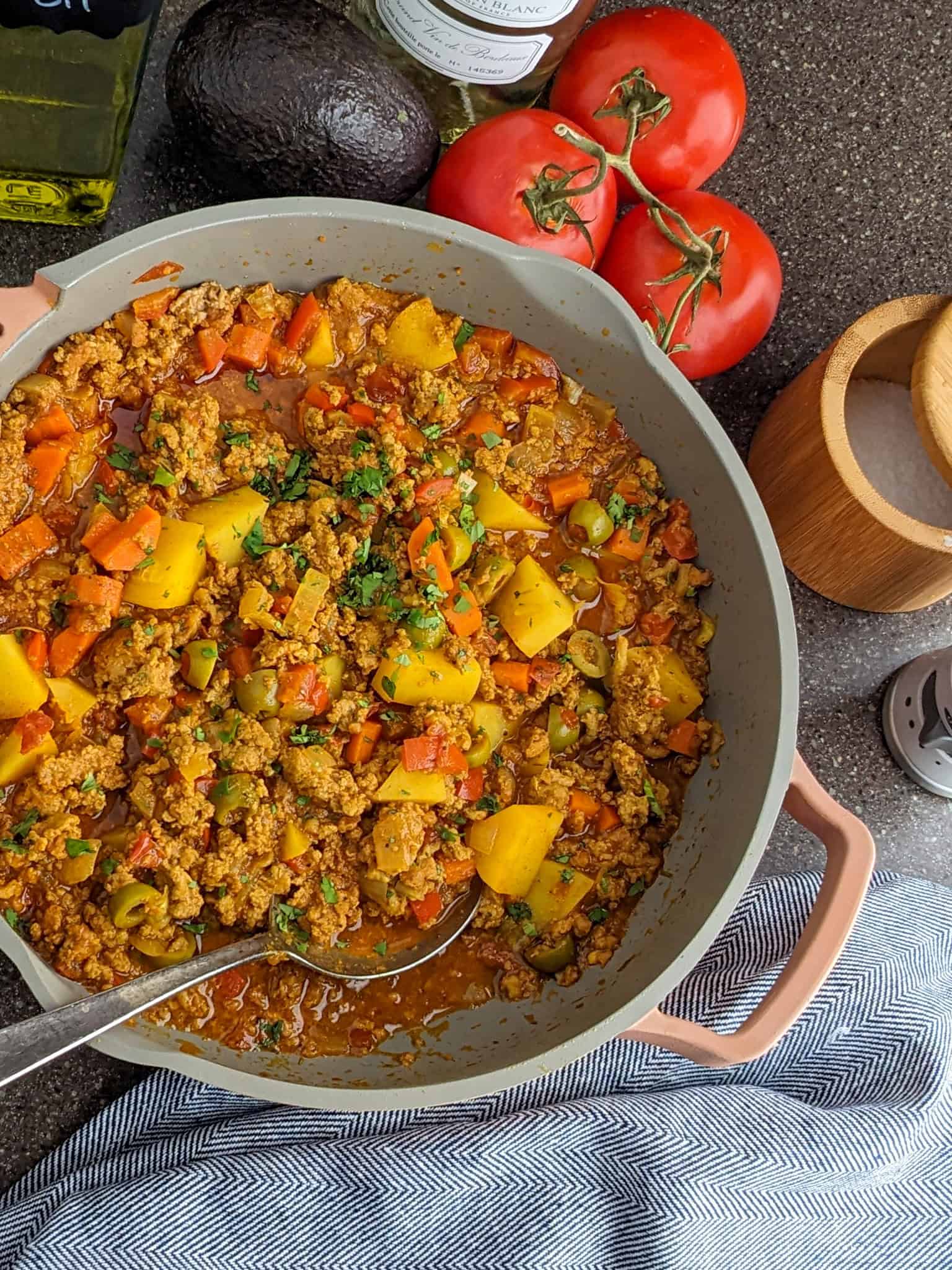 ground turkey picadillo in saute pan surrounded by ingredients.