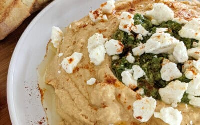 upclose picture of hummus with zhoug and feta cheese