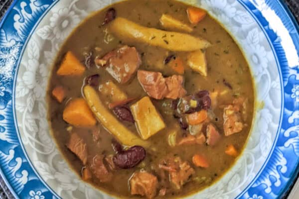 turkey red bean stew in a bowl held in hand