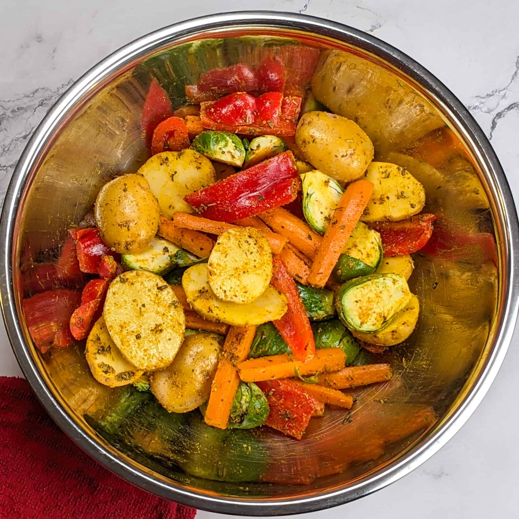 seasoned vegetables in a large mixing bowl for the Calabrian Pepper & Lemon Yogurt Baked Chicken and Vegetables recipe