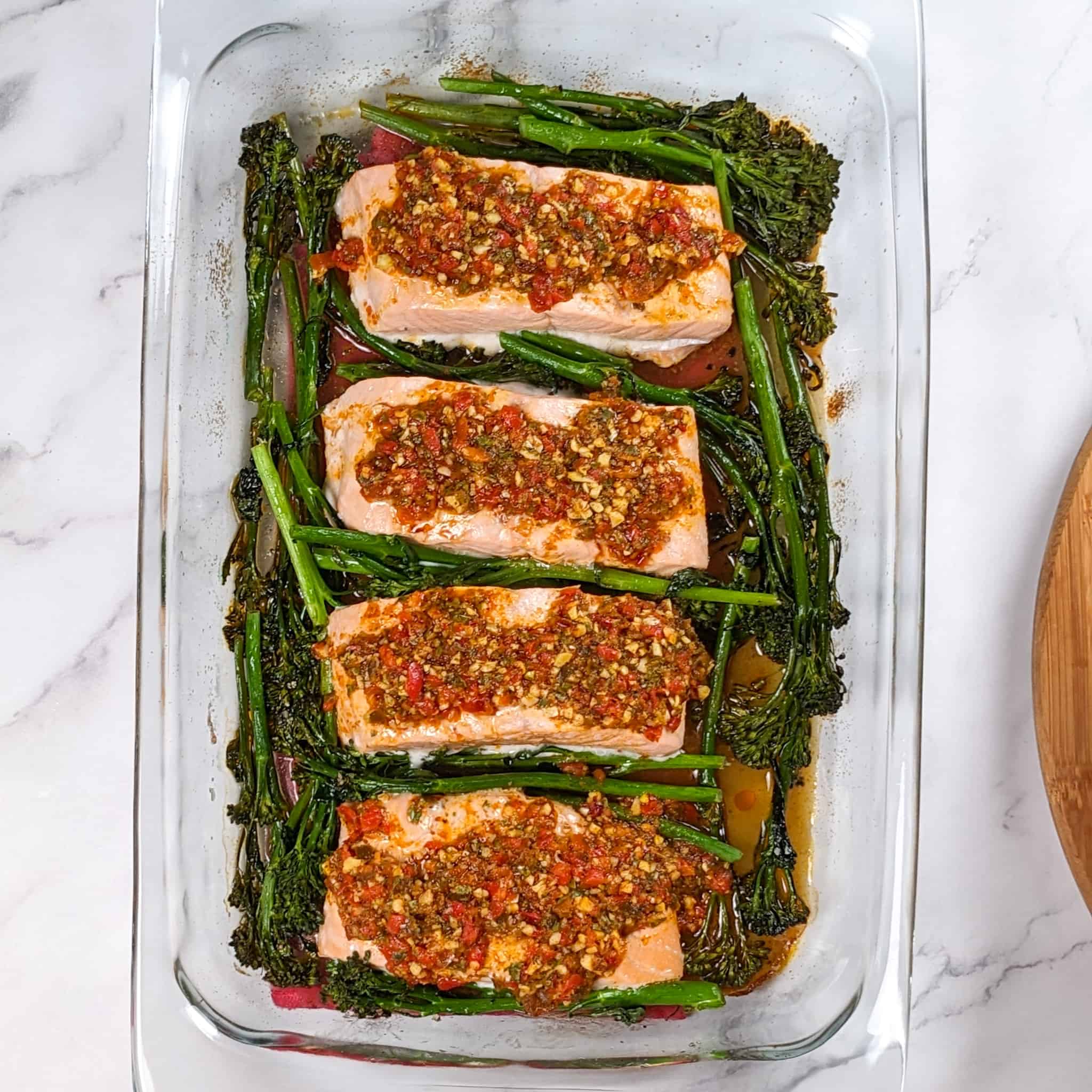 Top view of the Calabrian Pepper Basil Baked Salmon and Broccolini in a large glass rectangle baking dish