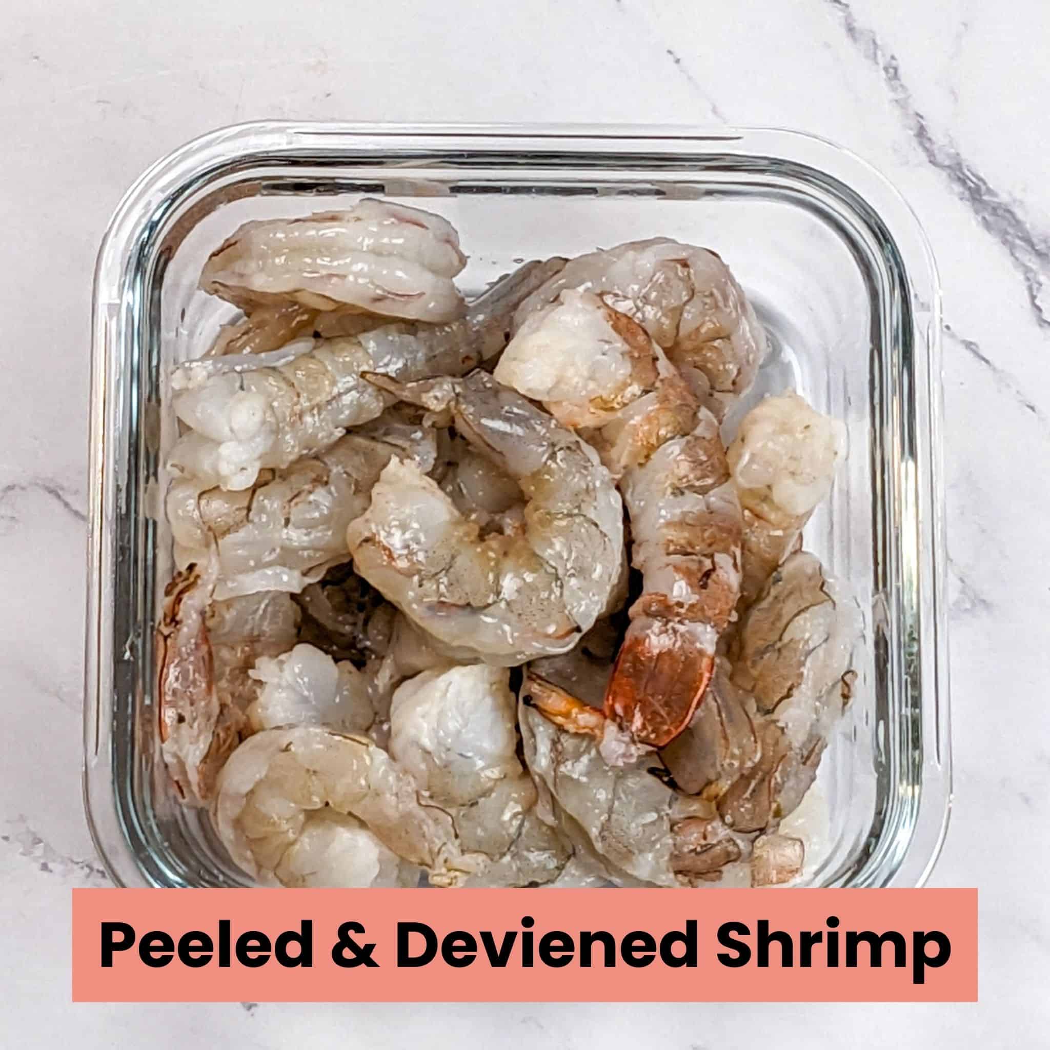peel and deveined raw shrimp in a square glass container.