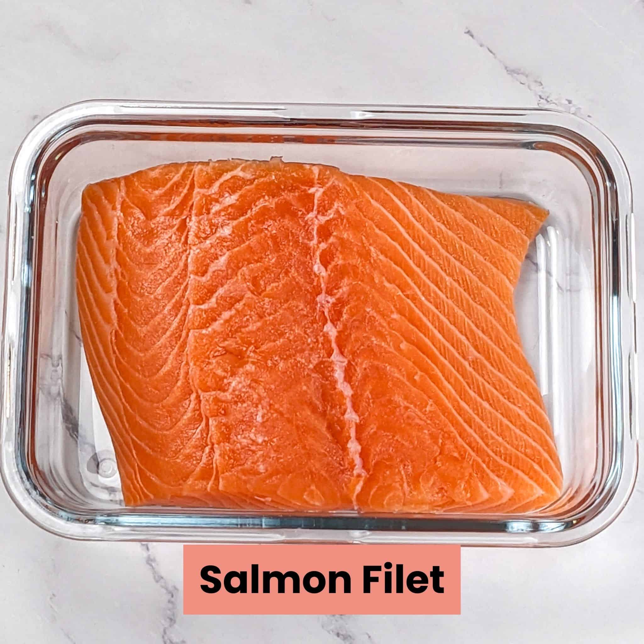 large piece of salmon filet in a glass rectangle container.