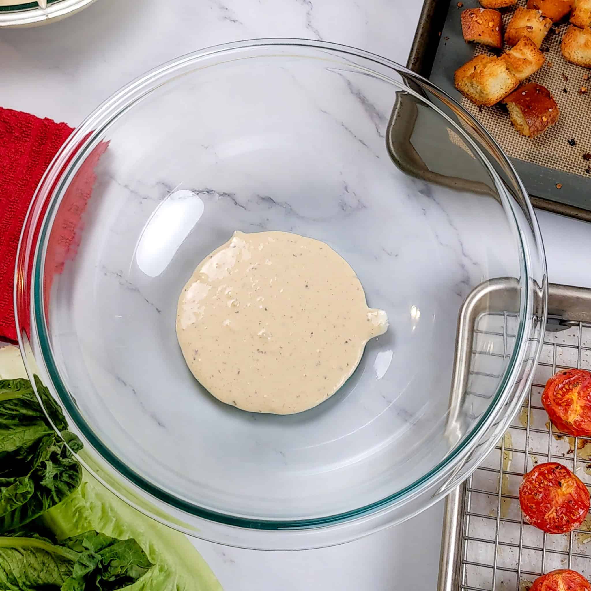 caesar salad dressing in a glass mixing bowl.