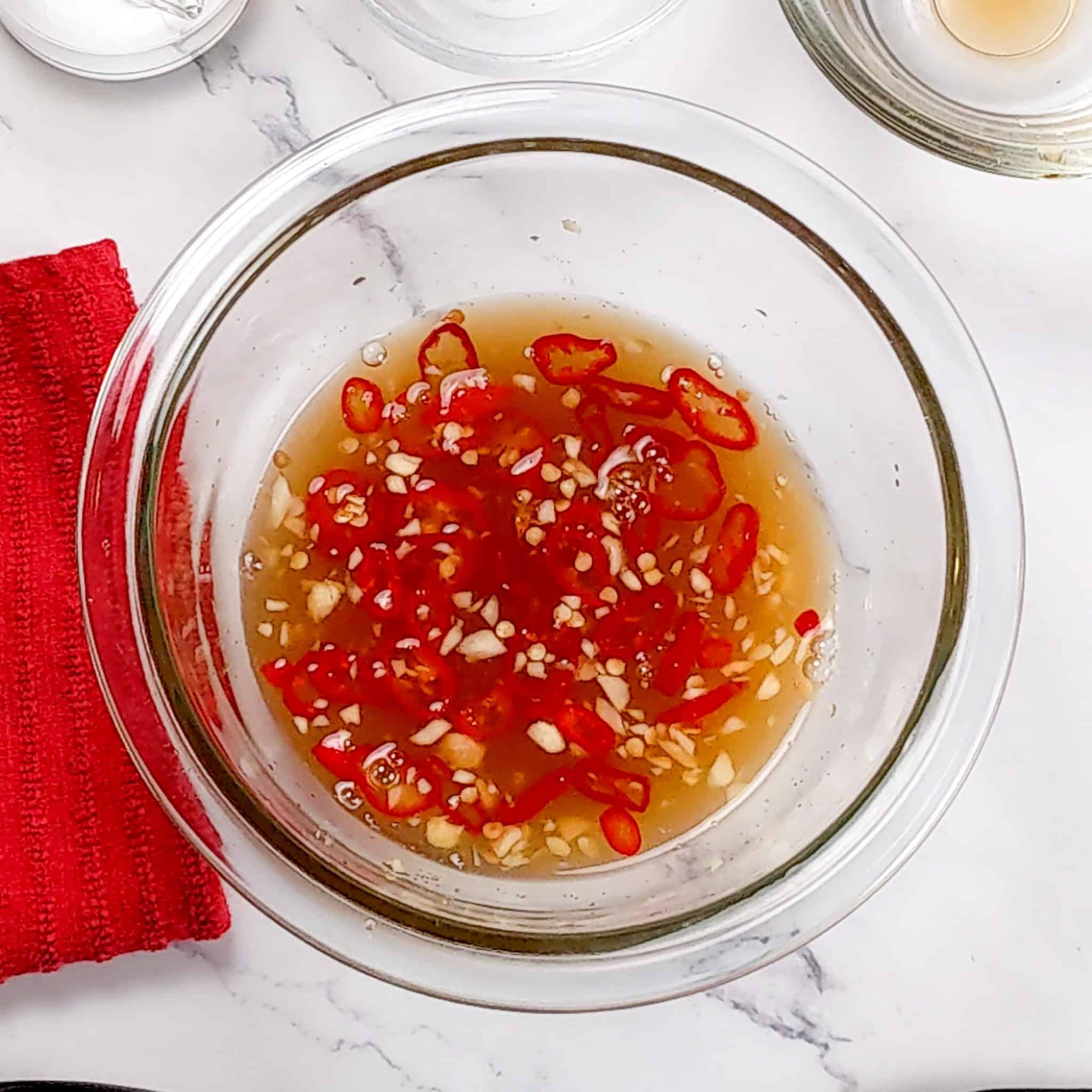 nouc cham sauce in a glass container.