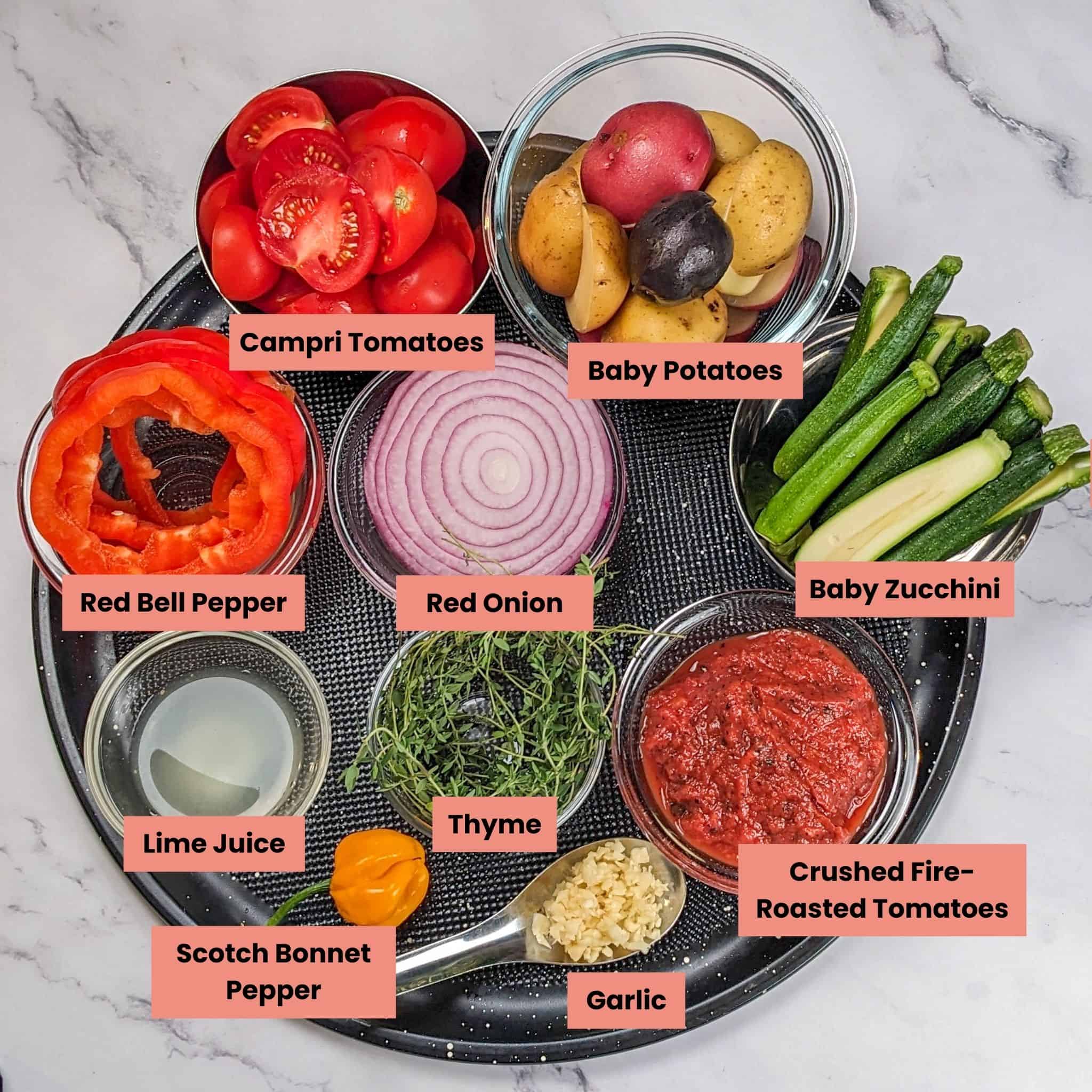 ingredients for the Seared Snapper Spicy Creole Sauce and Roasted Vegetables in containers on a large round pizza pan.