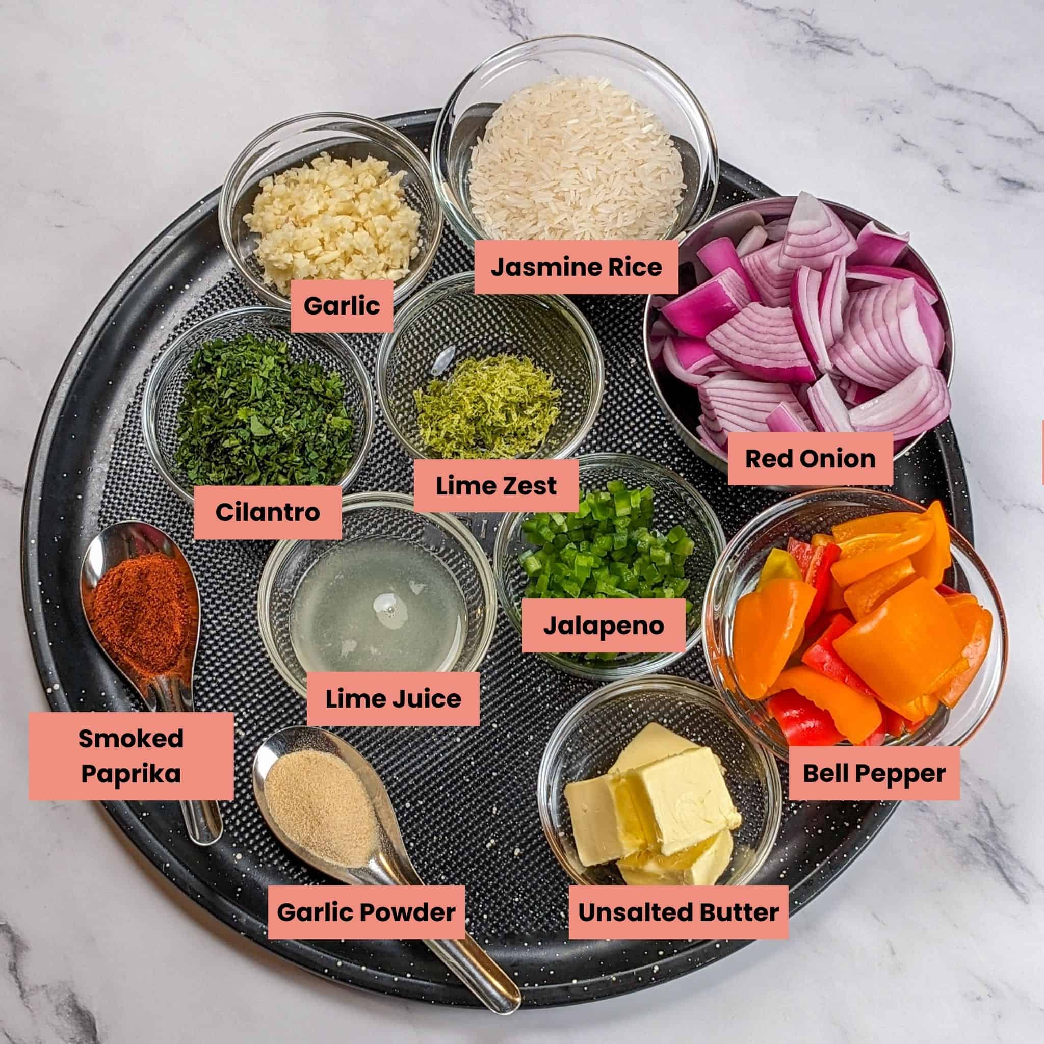 ingredients for the Grilled Shrimp Garlic Jalapeno Butter and Cilantro Lime Rice in containers on a large round pizza pan.