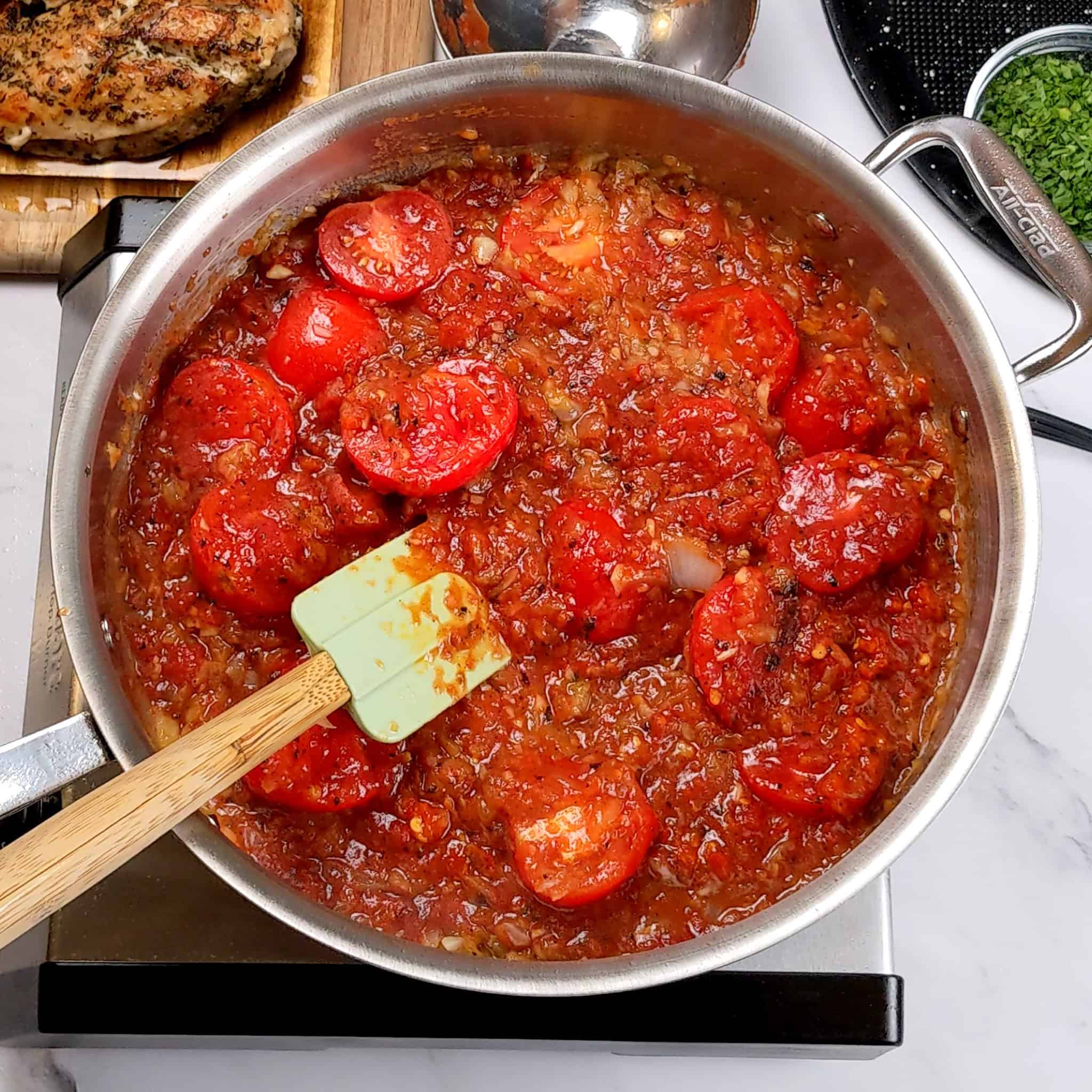 crushed fire roasted tomatoes, halved campari tomatoes cooking in an all-clad saute pan.