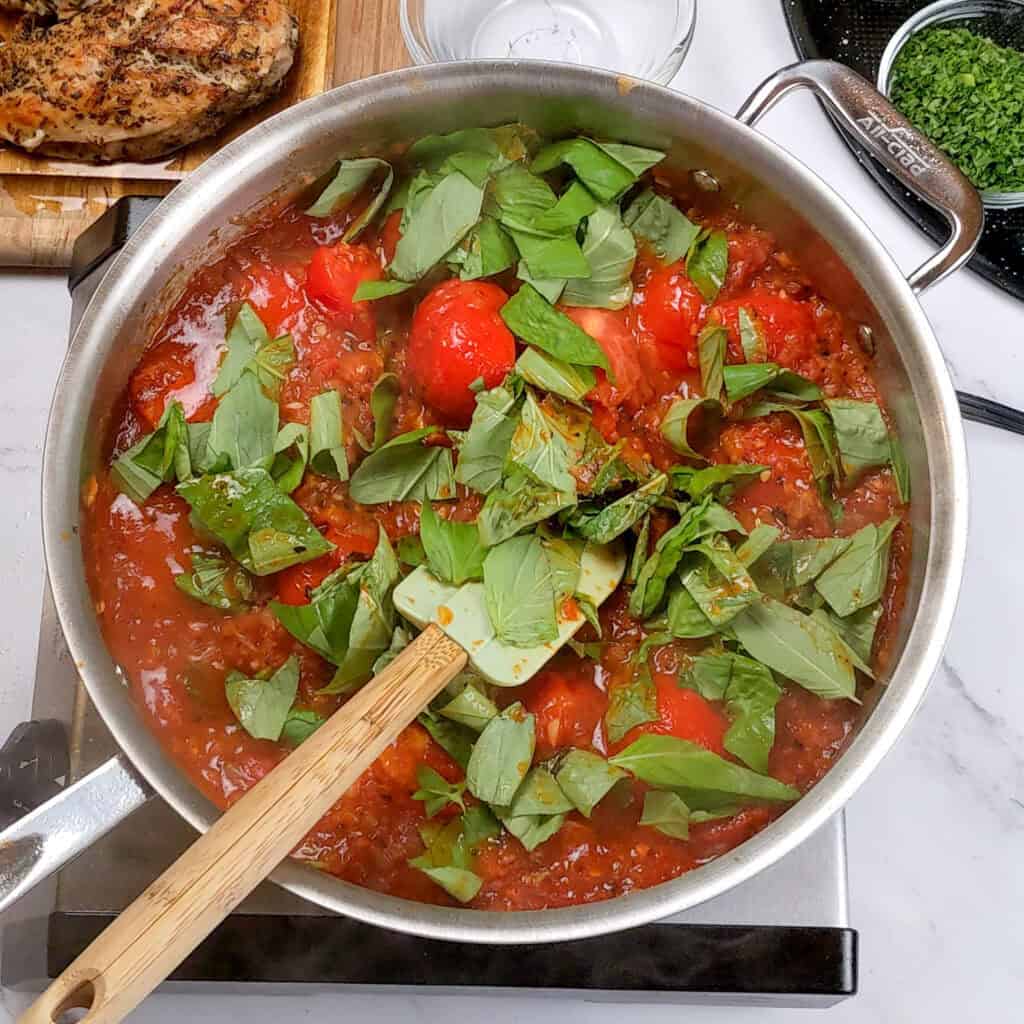 fresh torn basil leaves topped the tomato sauce in an all-clad saute pan.