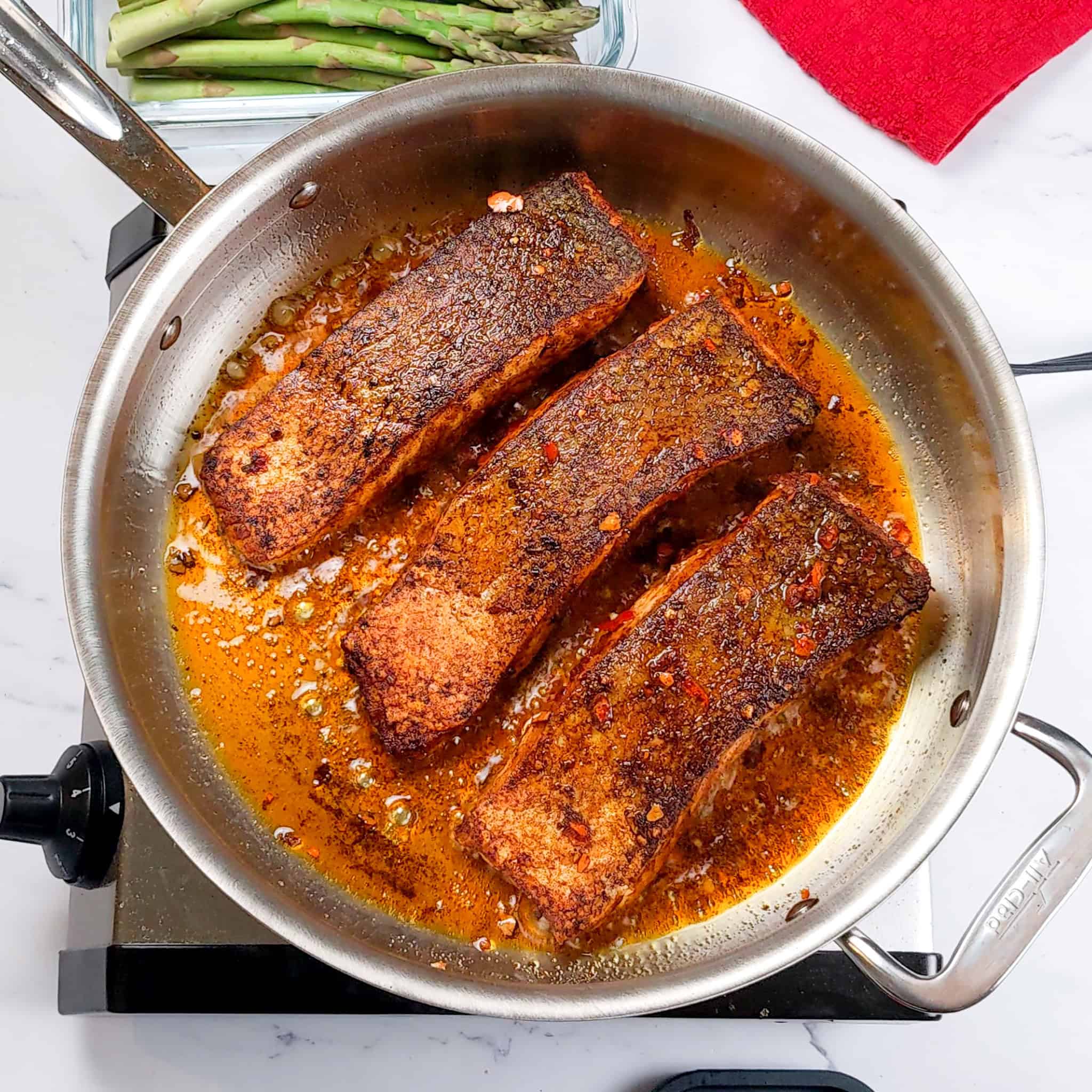 seared marinated salmon pan crisped skin side up in a all-clad large saute pan.