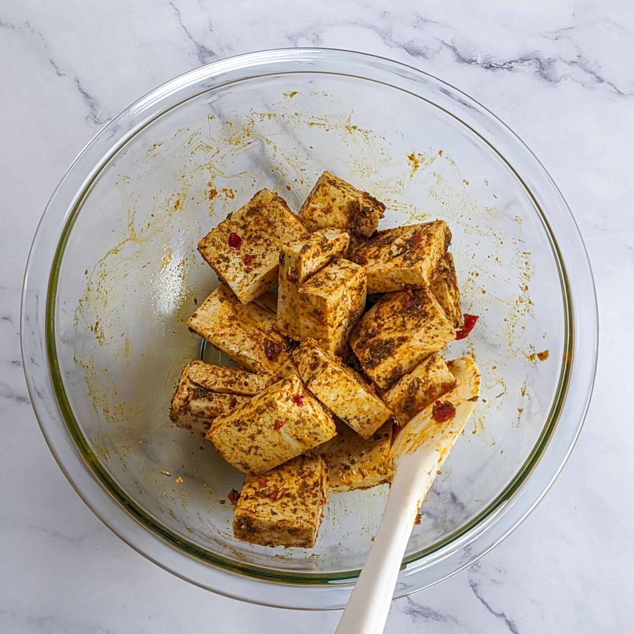 marinated tofu in a glass mixing bowl.