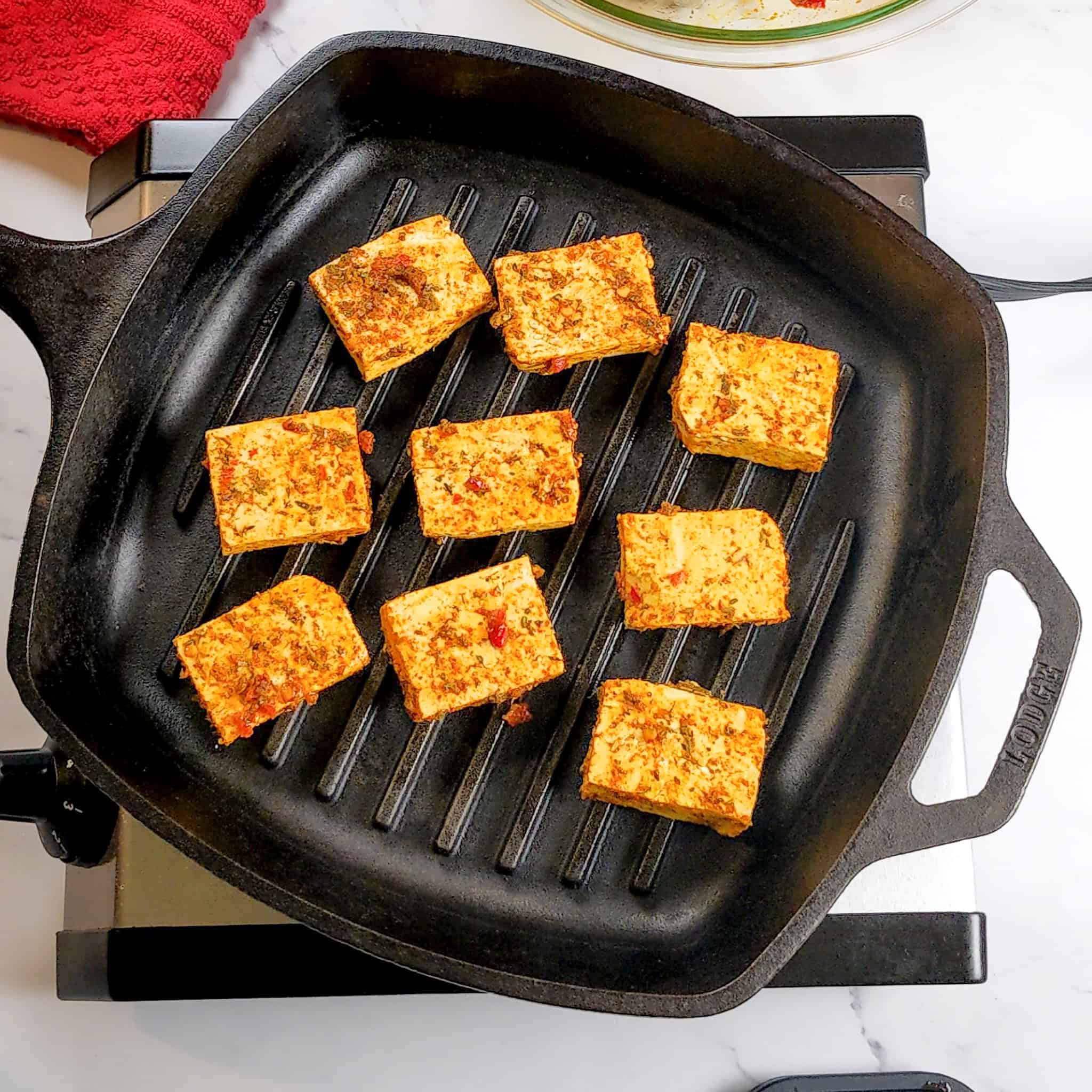 marinated tofu grilling in a grill pan.