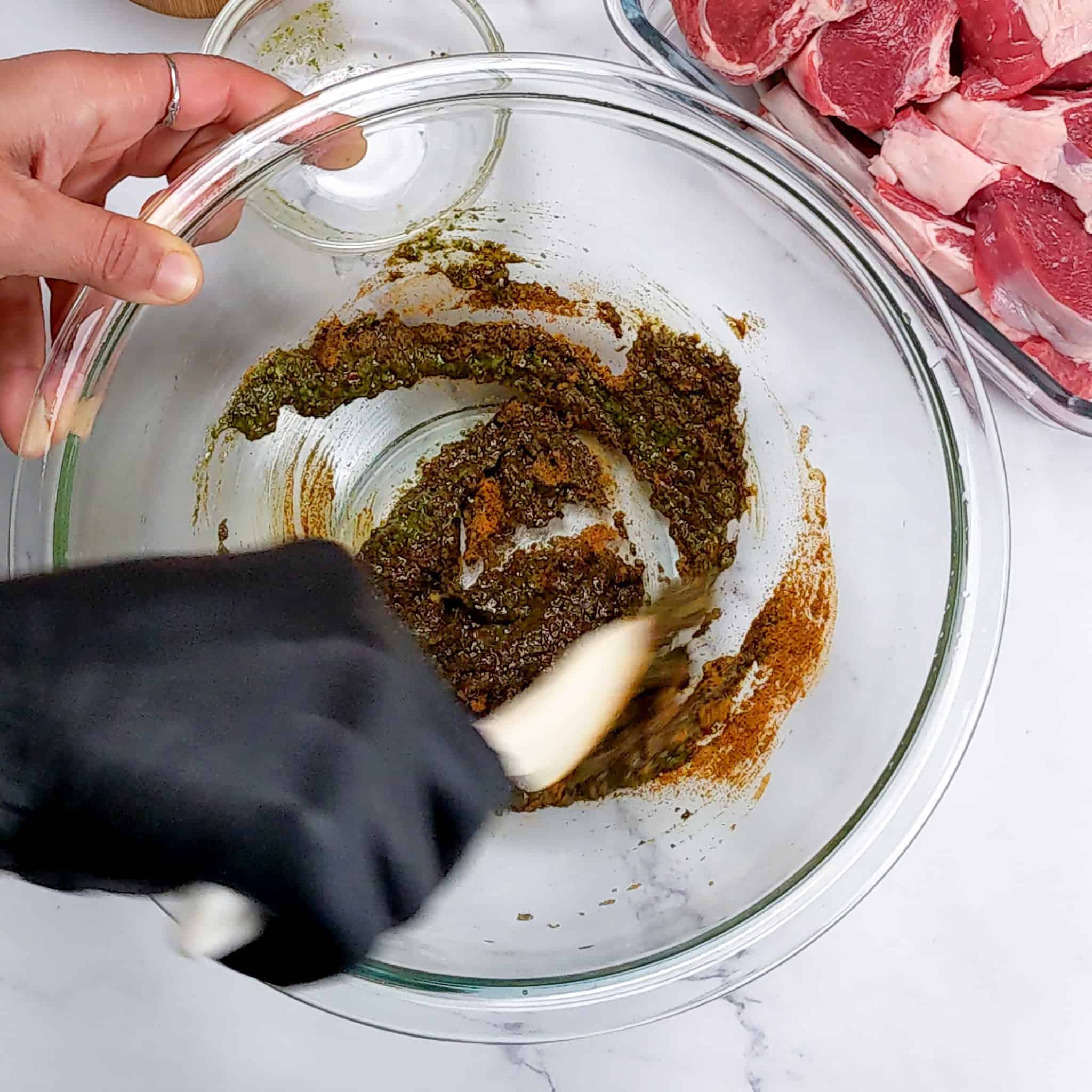 zhug ras el hanout wet rub being mixed in a pyrex glass mixing bowl.