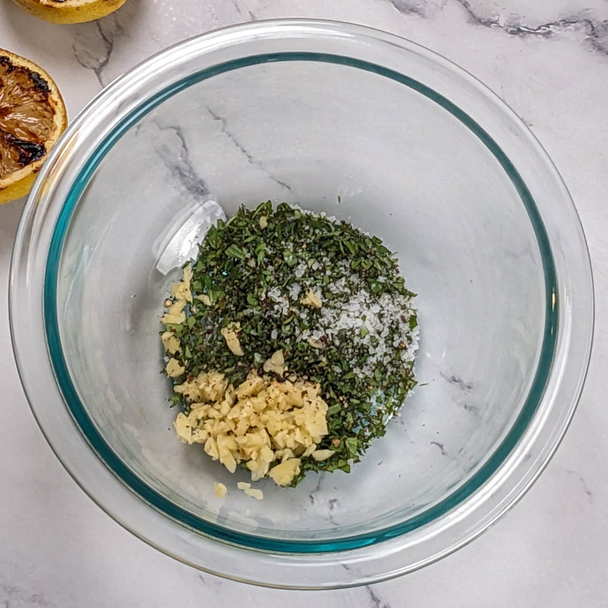 ingredients for the lemon oregano vinaigrette in a glass mixing bowl.