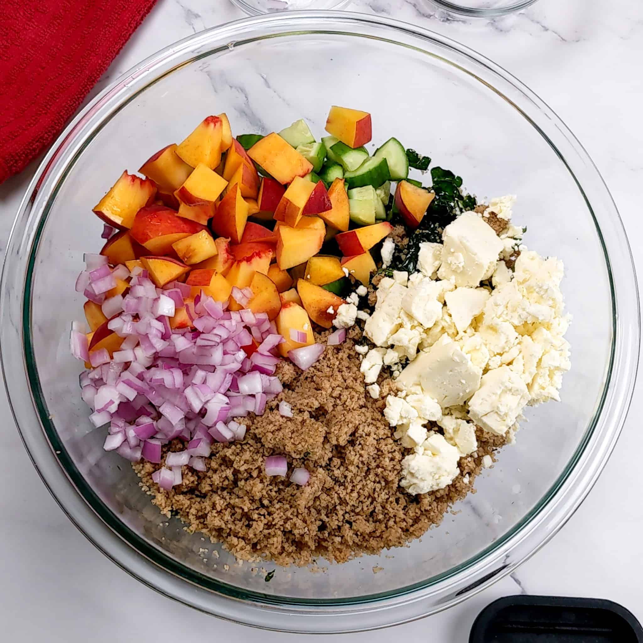 ingredients for the peach fonio kale salad in mixing bowl.