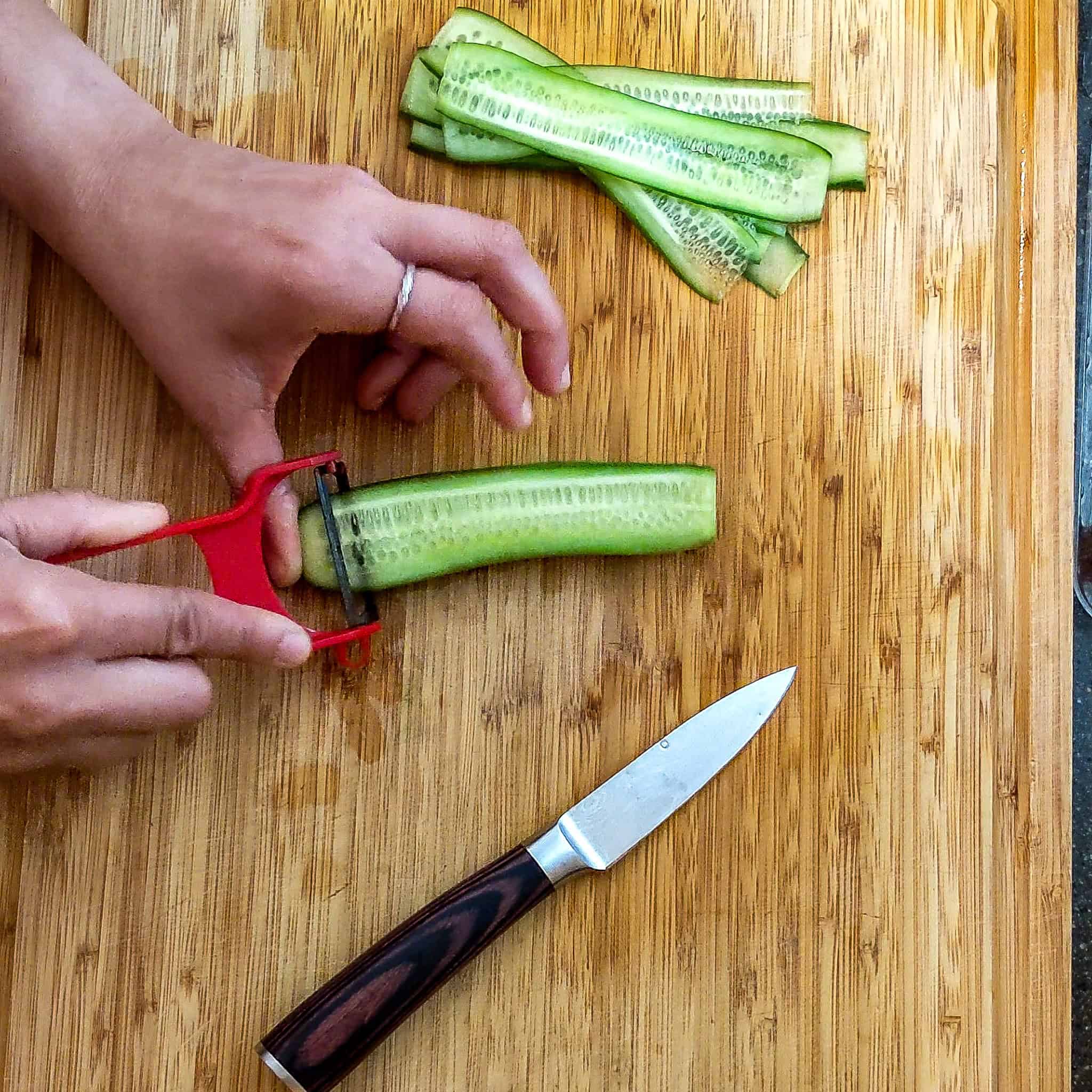 slicing a cucumber with a y shape peeler.