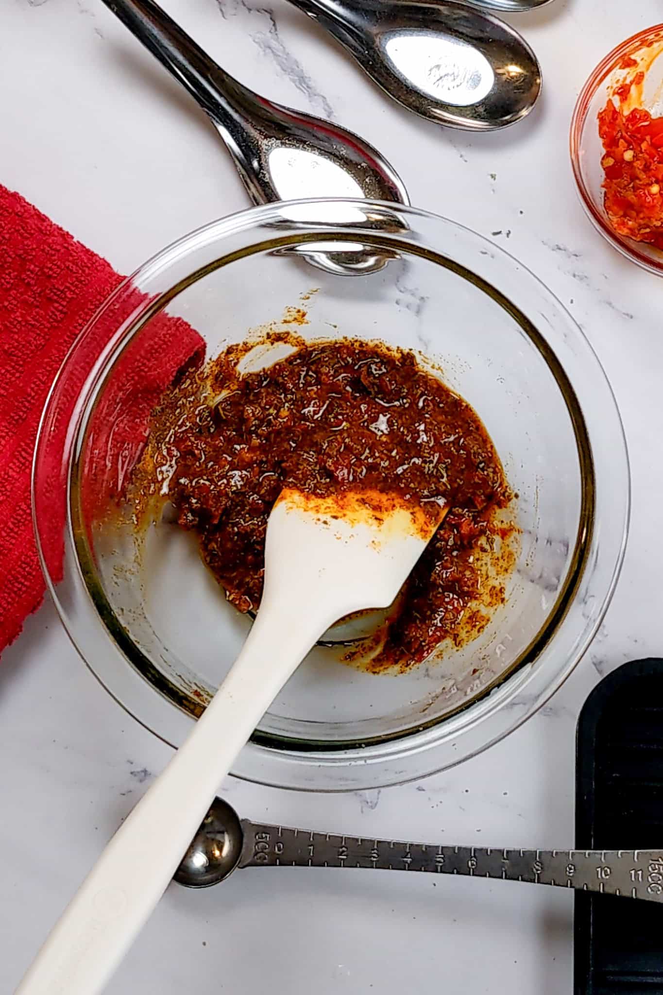 the turmeric calabiran chili pepper rub mixed in a glass pyrex mixing bowl.