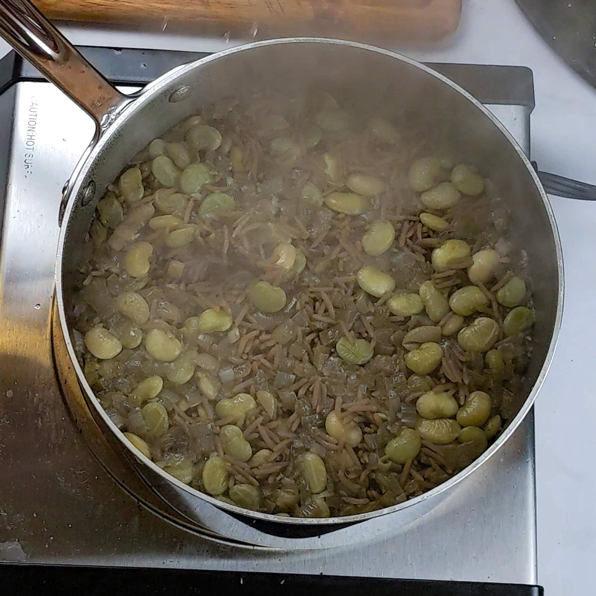 Djon Djon mushroom Black rice lima beans in a sauce pot.