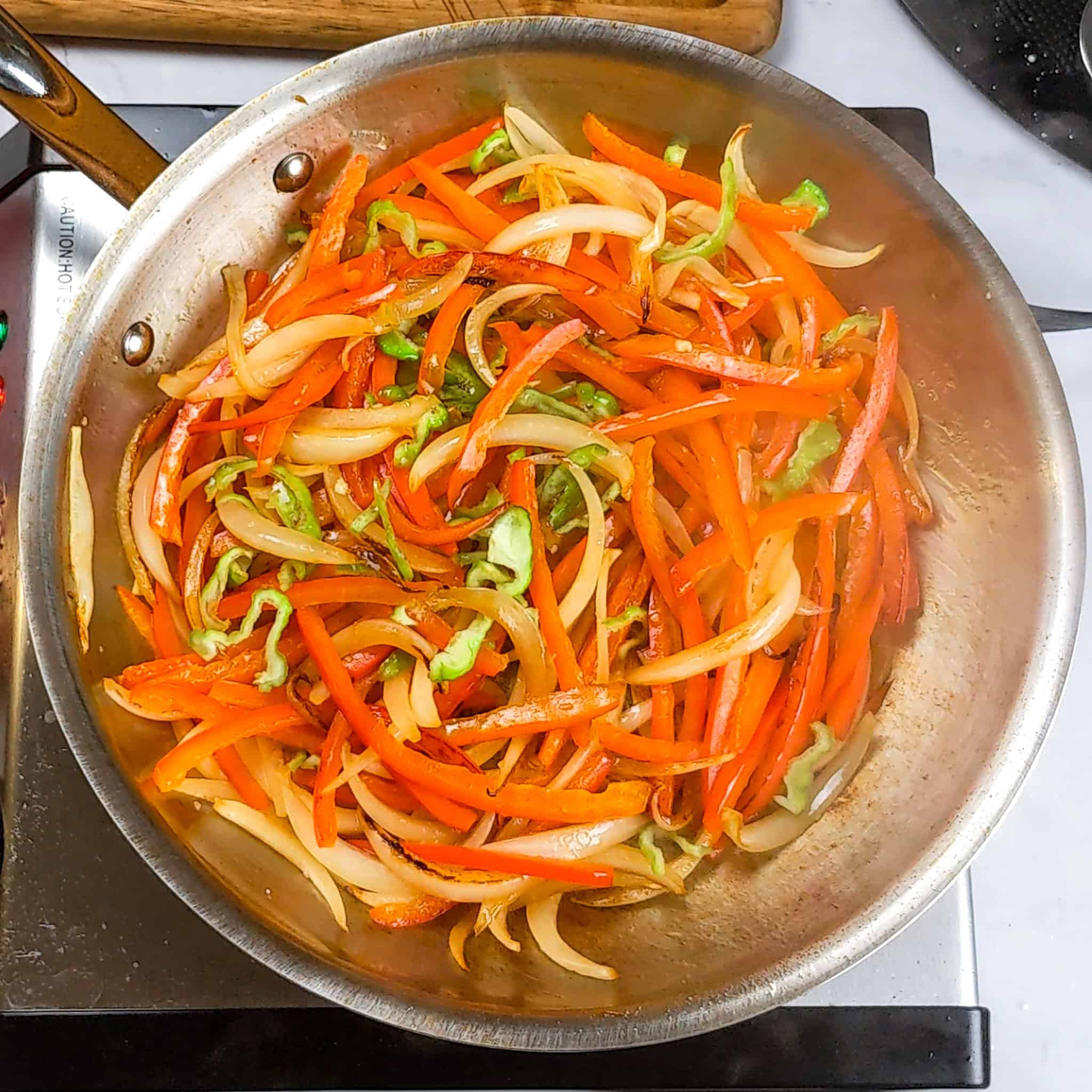 Thinly slice Scotch bonnet peppers added to the red bell peppers and onions.