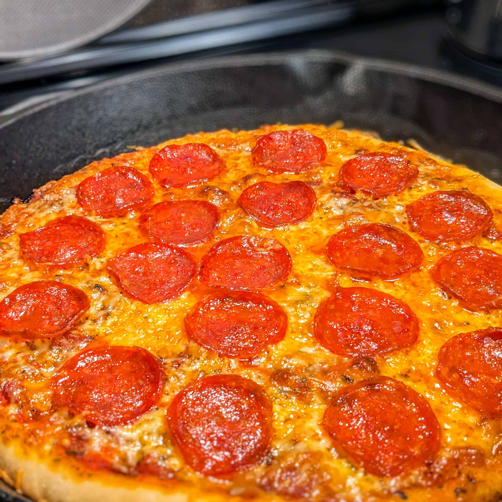 Pepperoni pizza in a cast iron skillet.