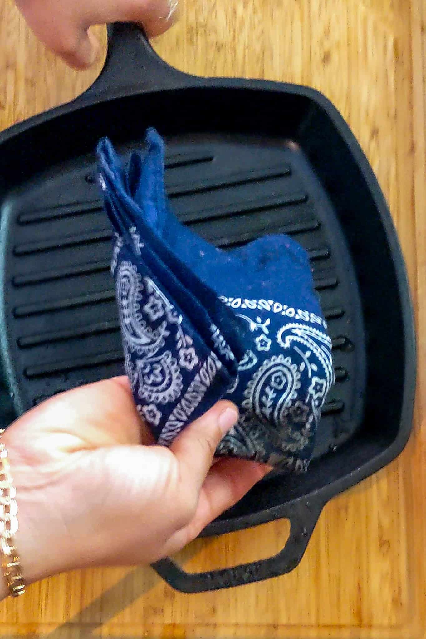 folded bandana held in hand above grill pan.