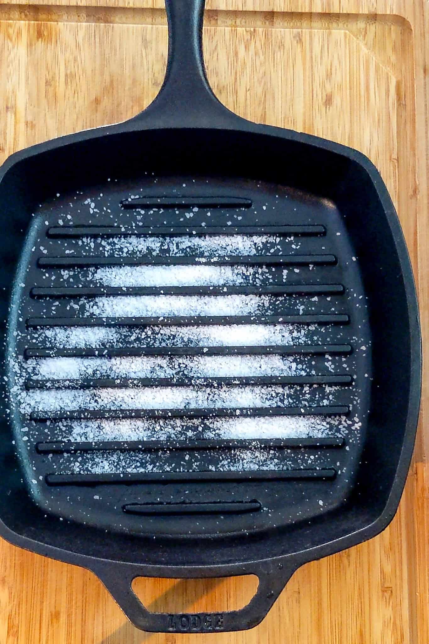 course salt spread out in a cast iron grill pan for cleaning.