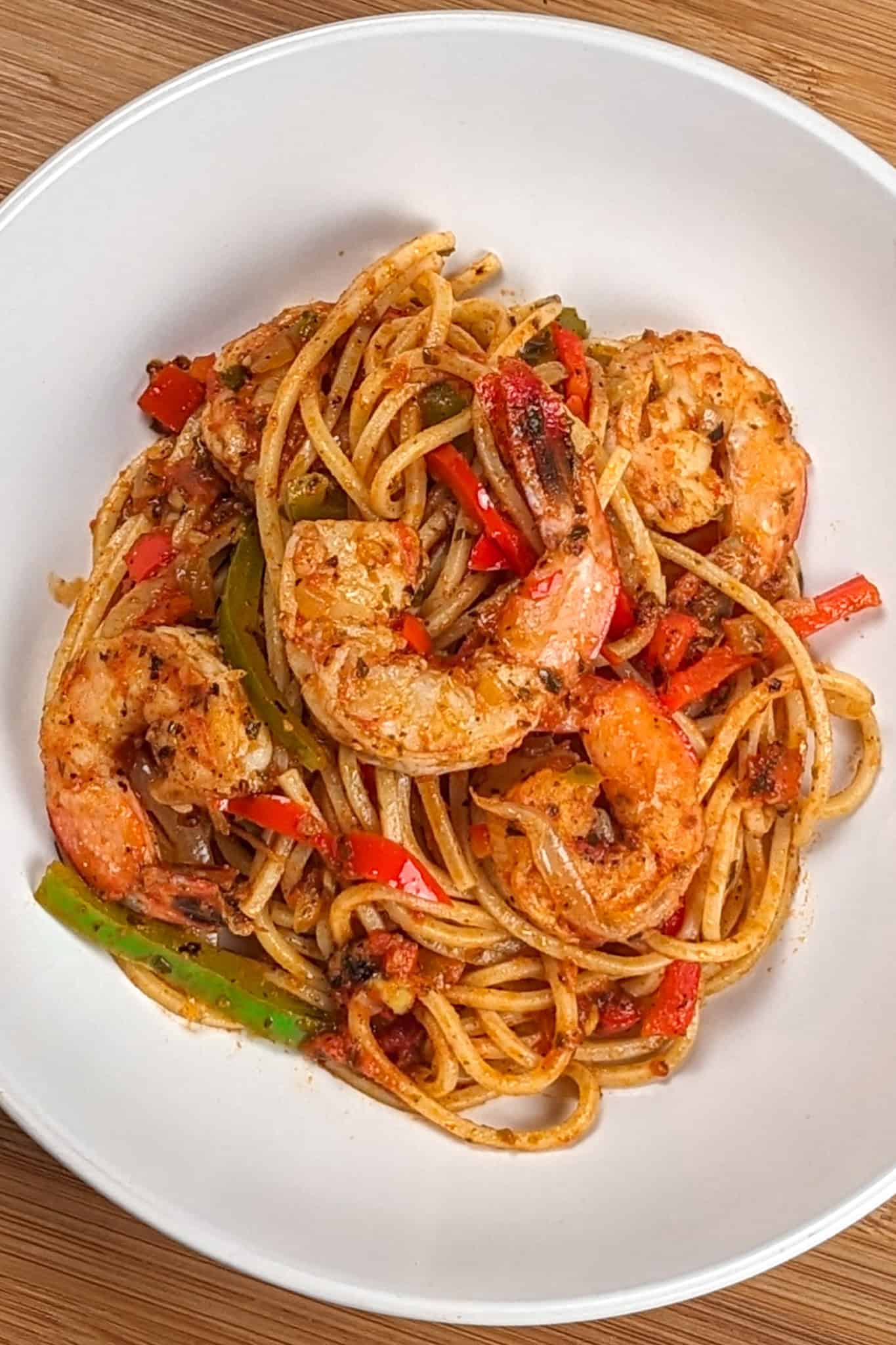 Top view of the Haitian-style spaghetti with shrimp and creole sauce in a wide-rim pasta bowl.