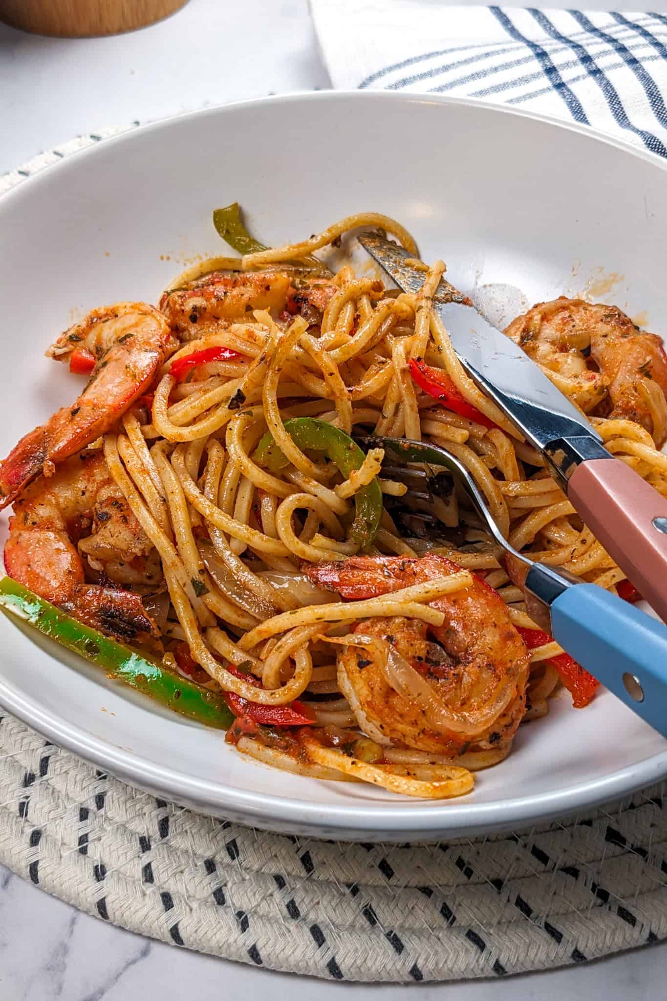 Haitian-style spaghetti with shrimp is eaten with a fork and a knife.