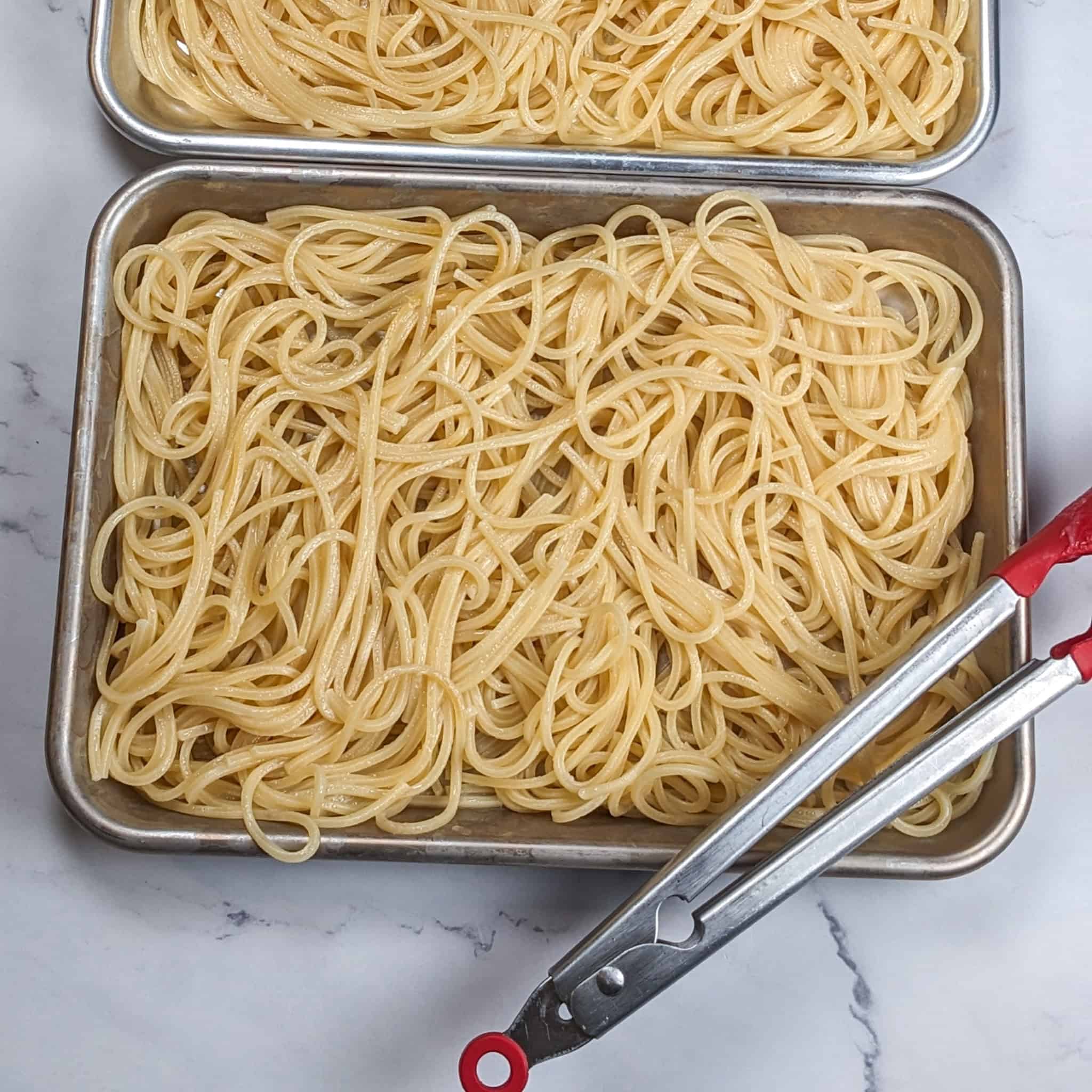 Cooled down pasta in small sheet pans.