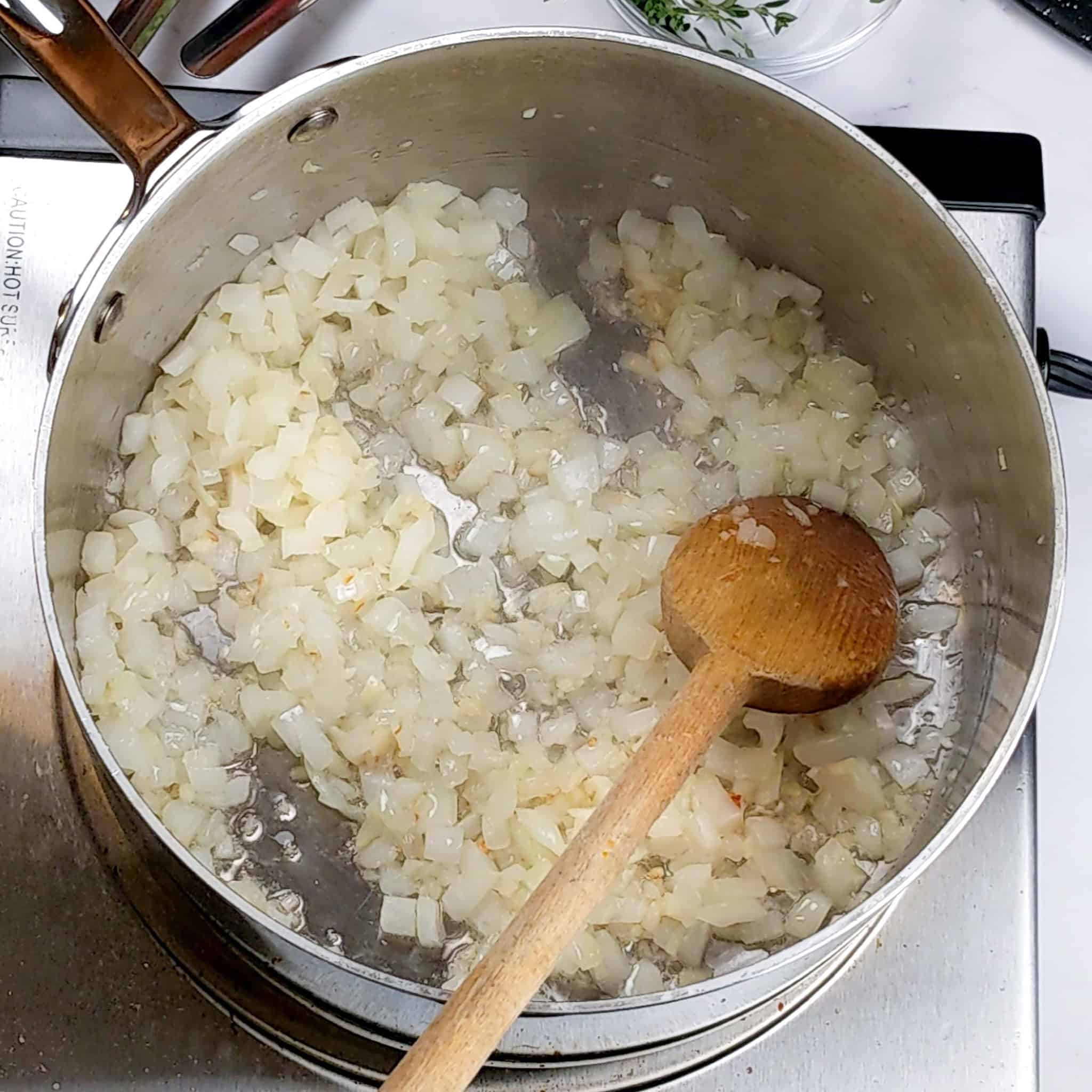 Translucent sauteed onions in a large sauce pot.