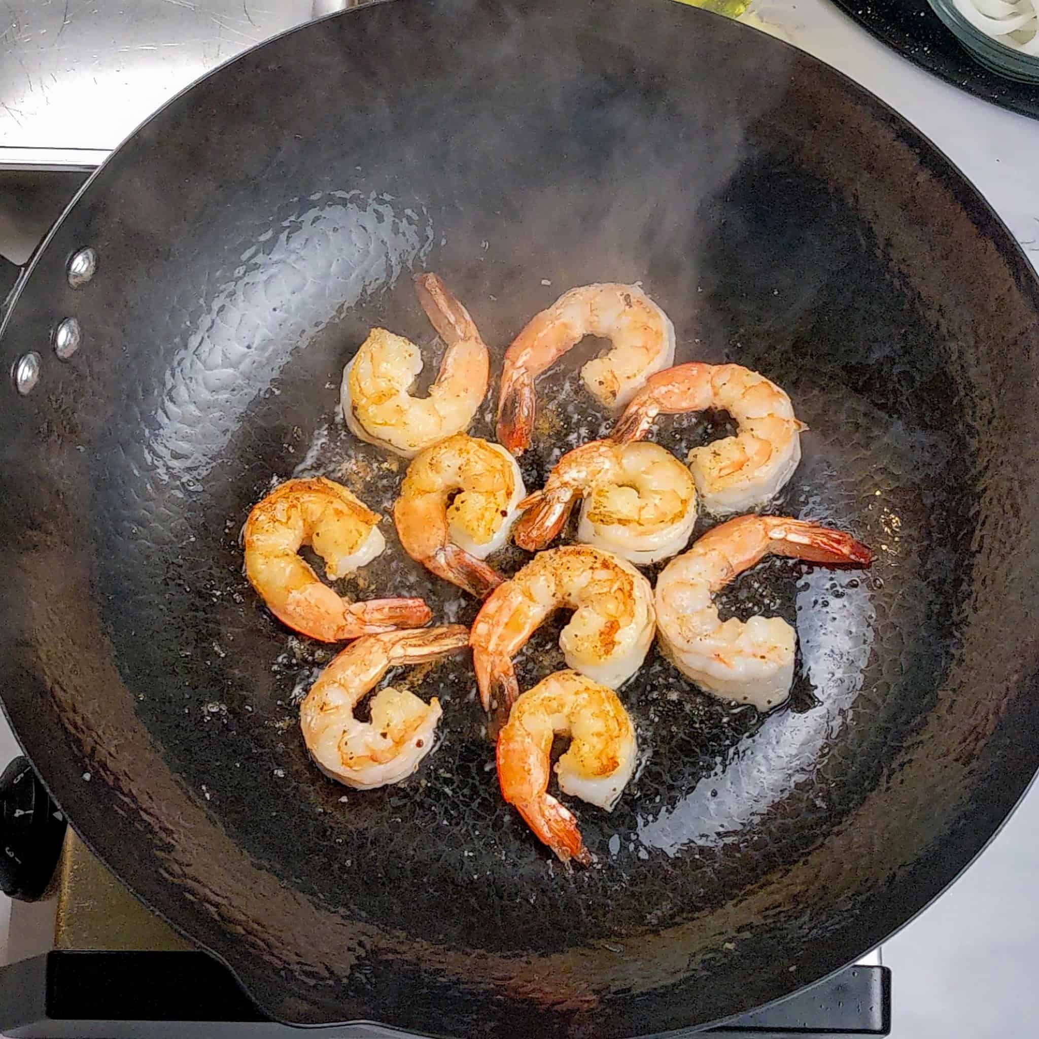 Shrimp searing in a wok.