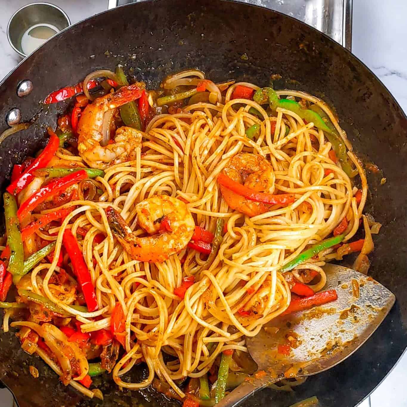 Spaghetti is added to the shrimp pasta sauce