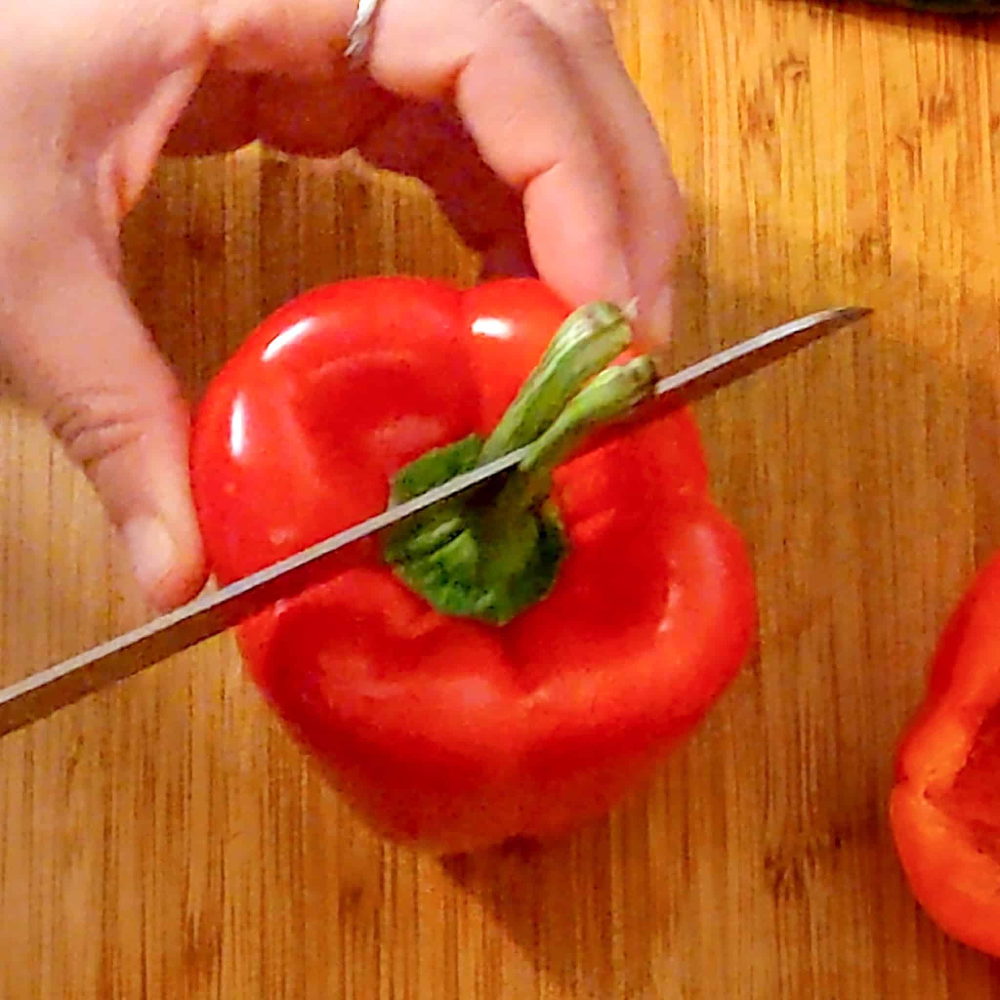 A knife Place between the split stem cutting through the bell pepper.