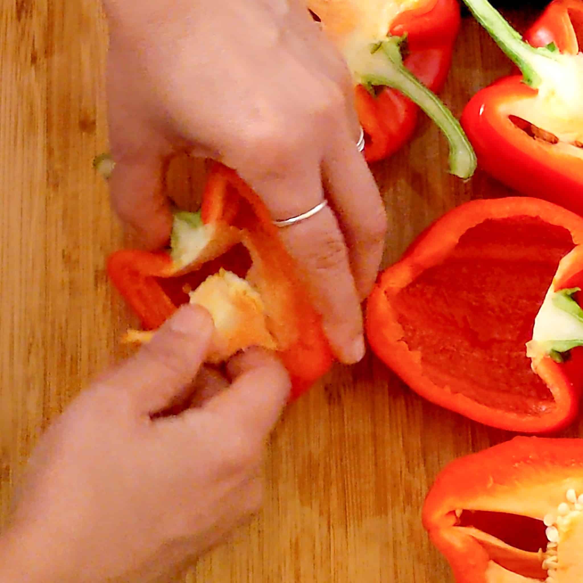 He hand removing the core and piss from the bell pepper.