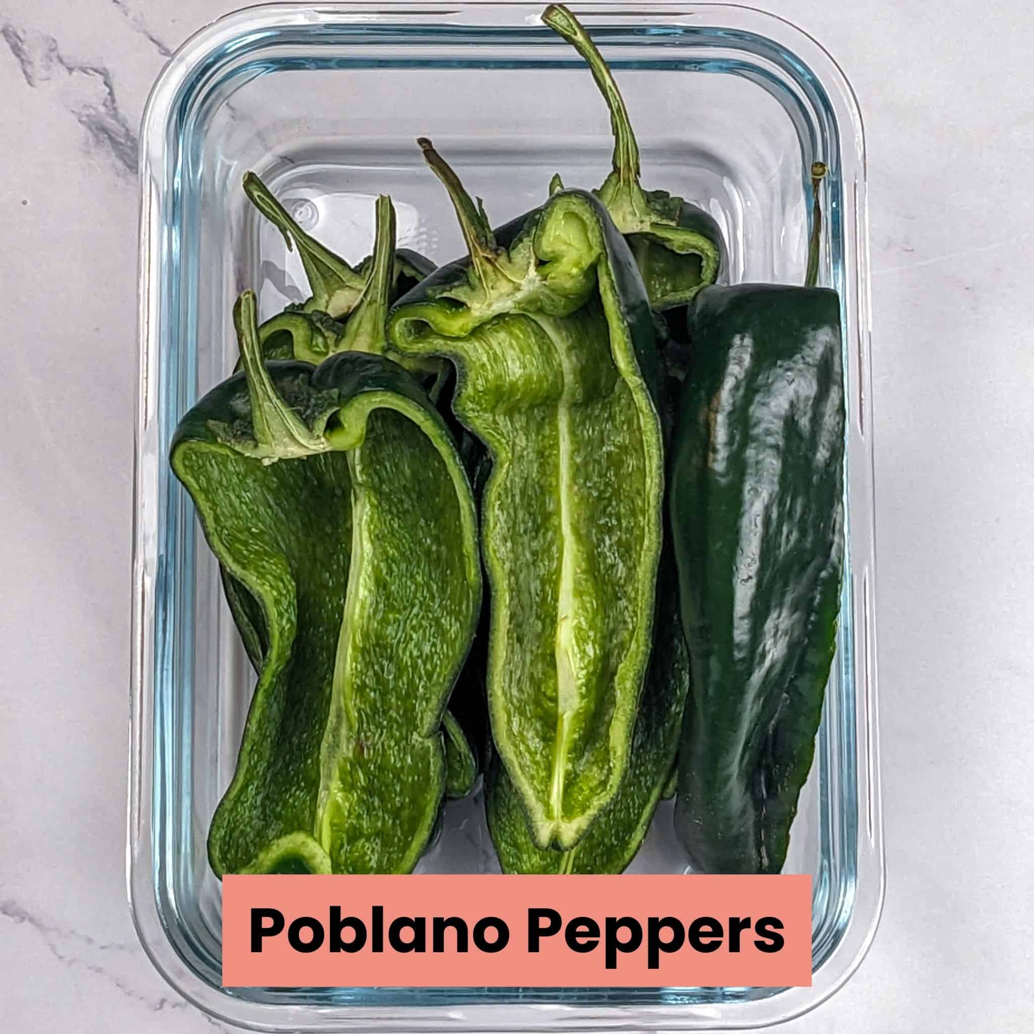 Halved poblano peppers in a rectangular glass dish.