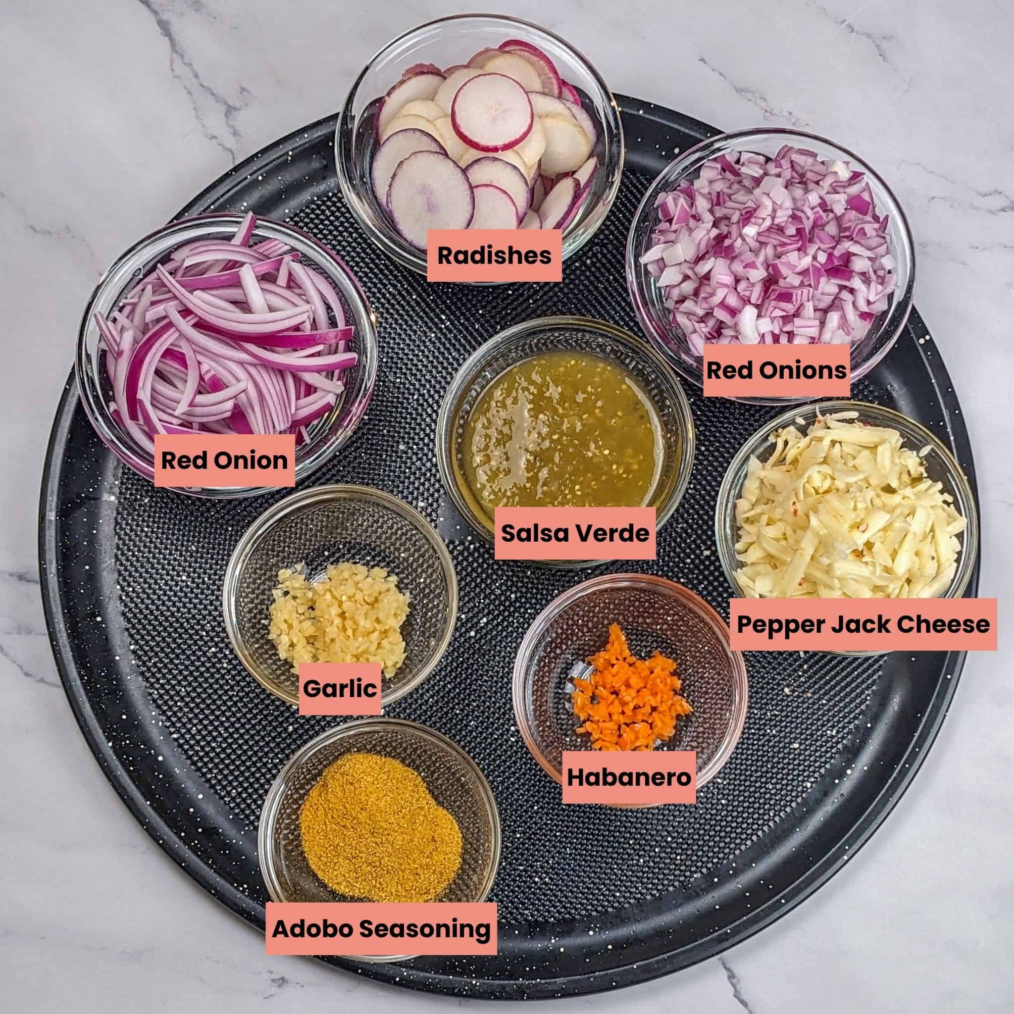 Ingredients for the healthy spicy ground turkey stuffed peppers with salad in glass containers on a round Pizza Pan.