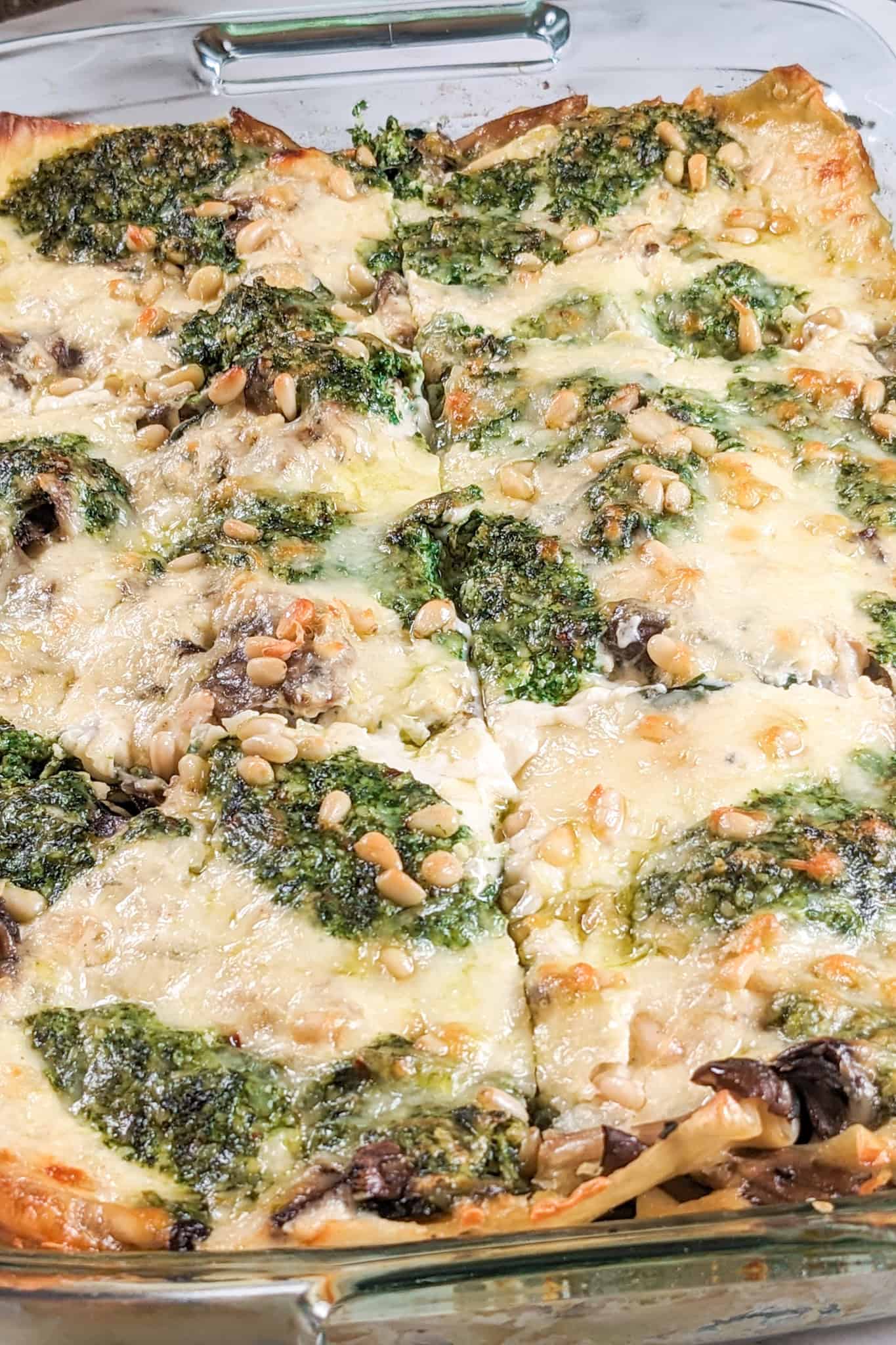 top view of the Creamy Spinach Pesto Mushroom Lasagna cut into 6 in a 13 by 9 glass pyrex baking dish.