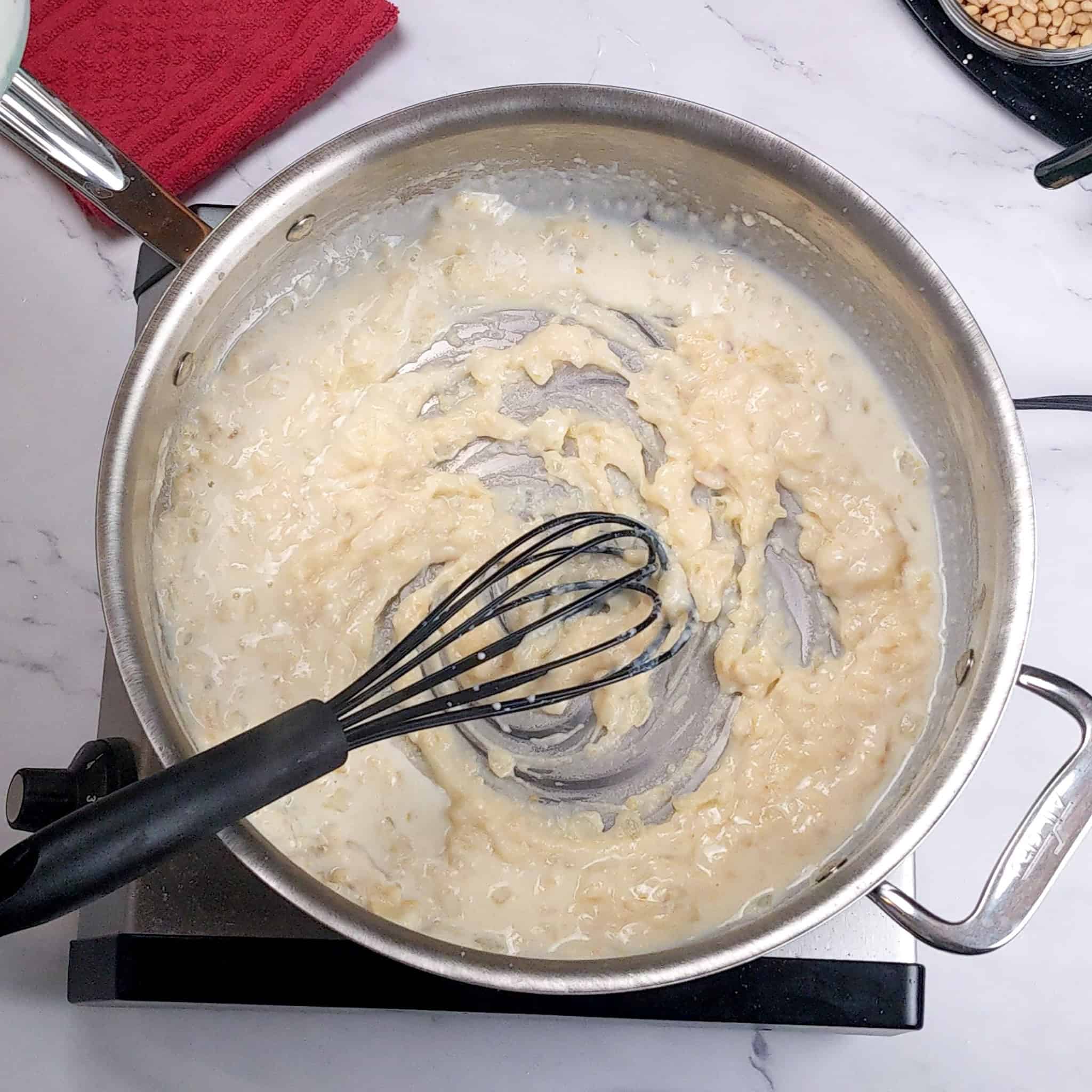 Roux in an All-Clad saute pan whisked with a silicone whisk.