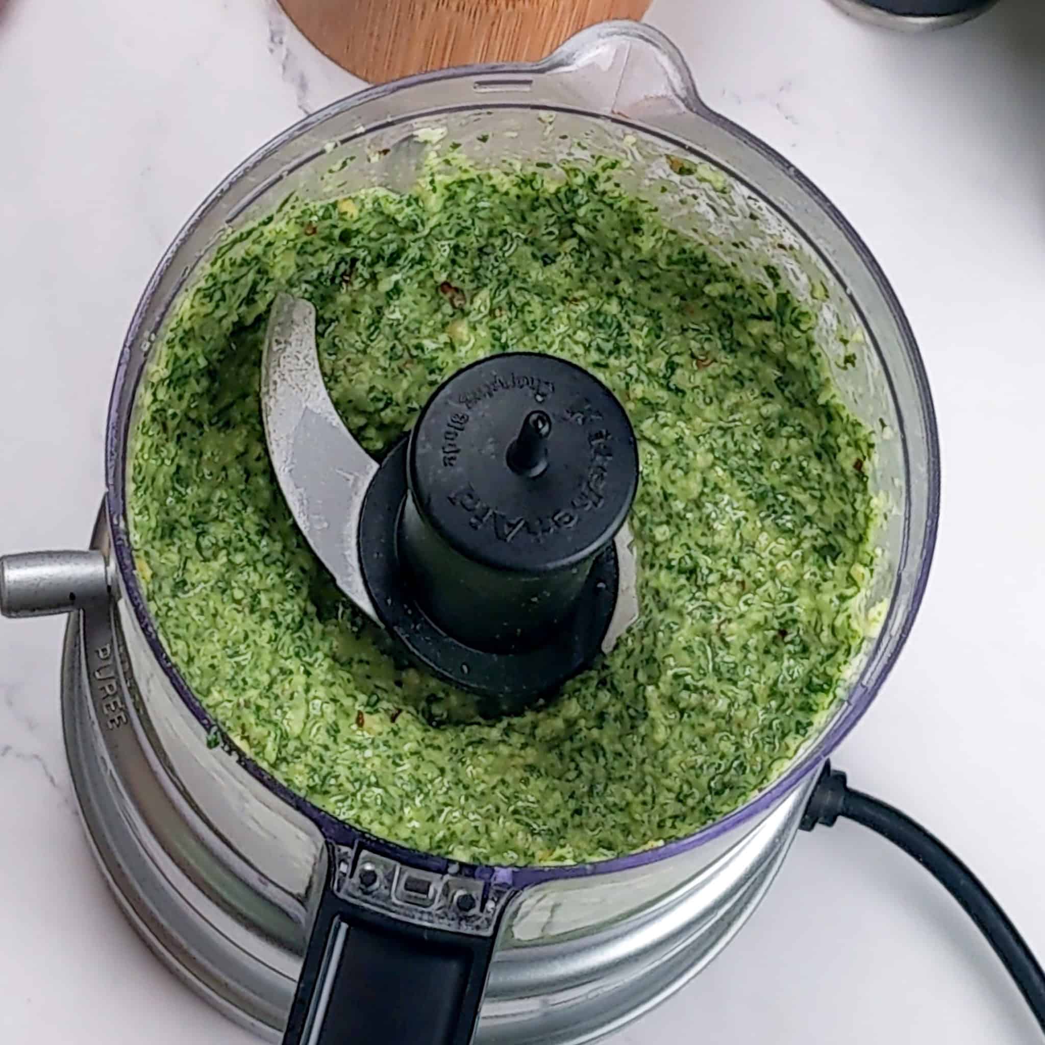 The finished product of the spicy spinach basil pesto in the open food processor.