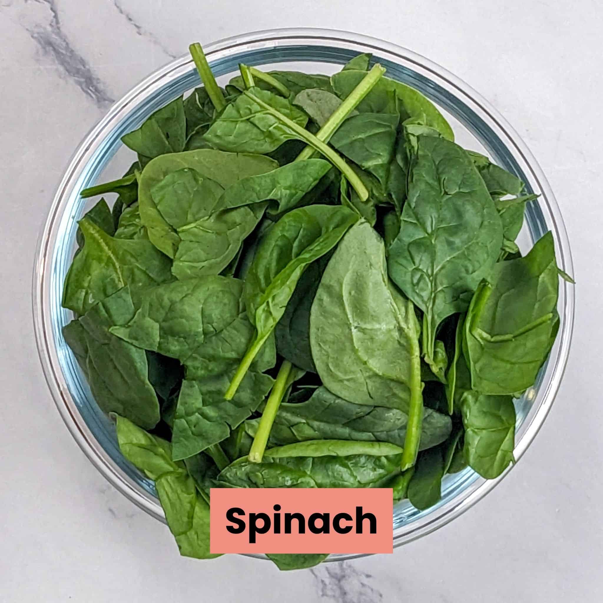 Fresh baby spinach in a deep glass round dish.