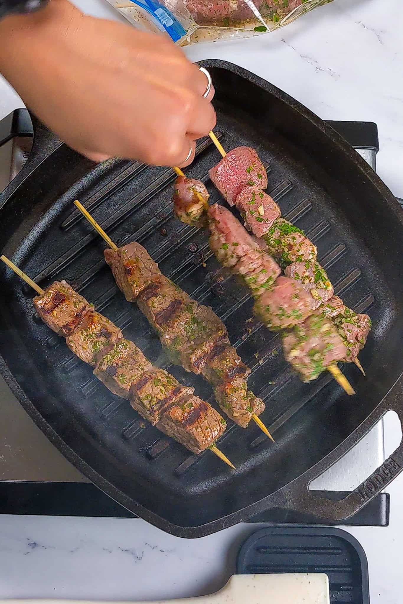 Grilling the marinaded beef kabobs.