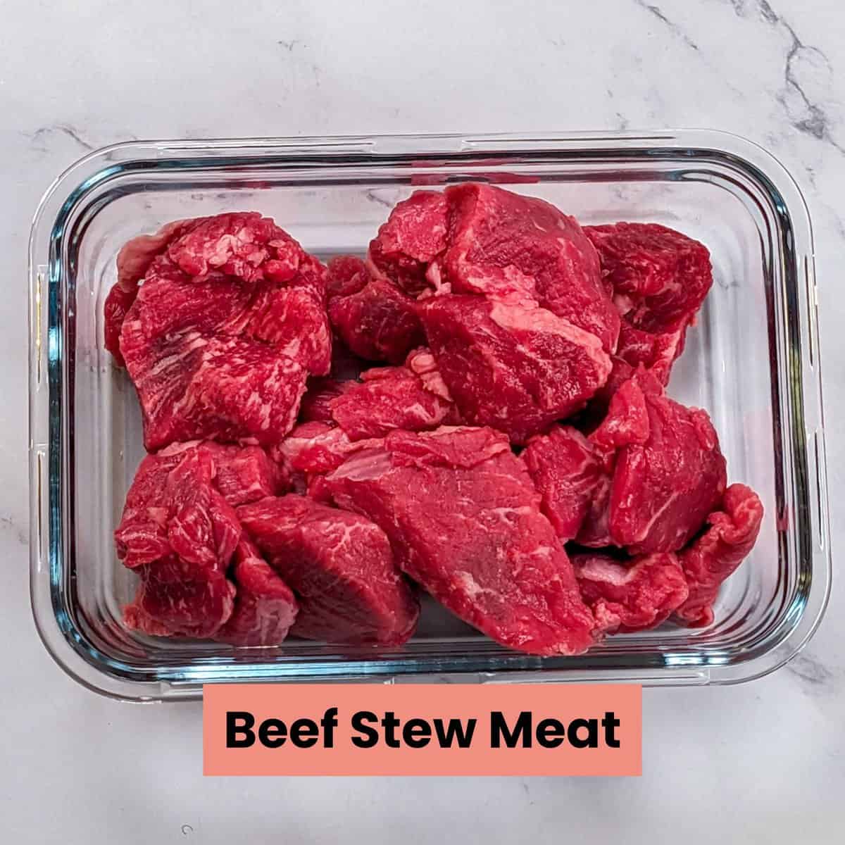 Fresh beef stew meat chunks in a clear glass container, perfect for hearty meals.