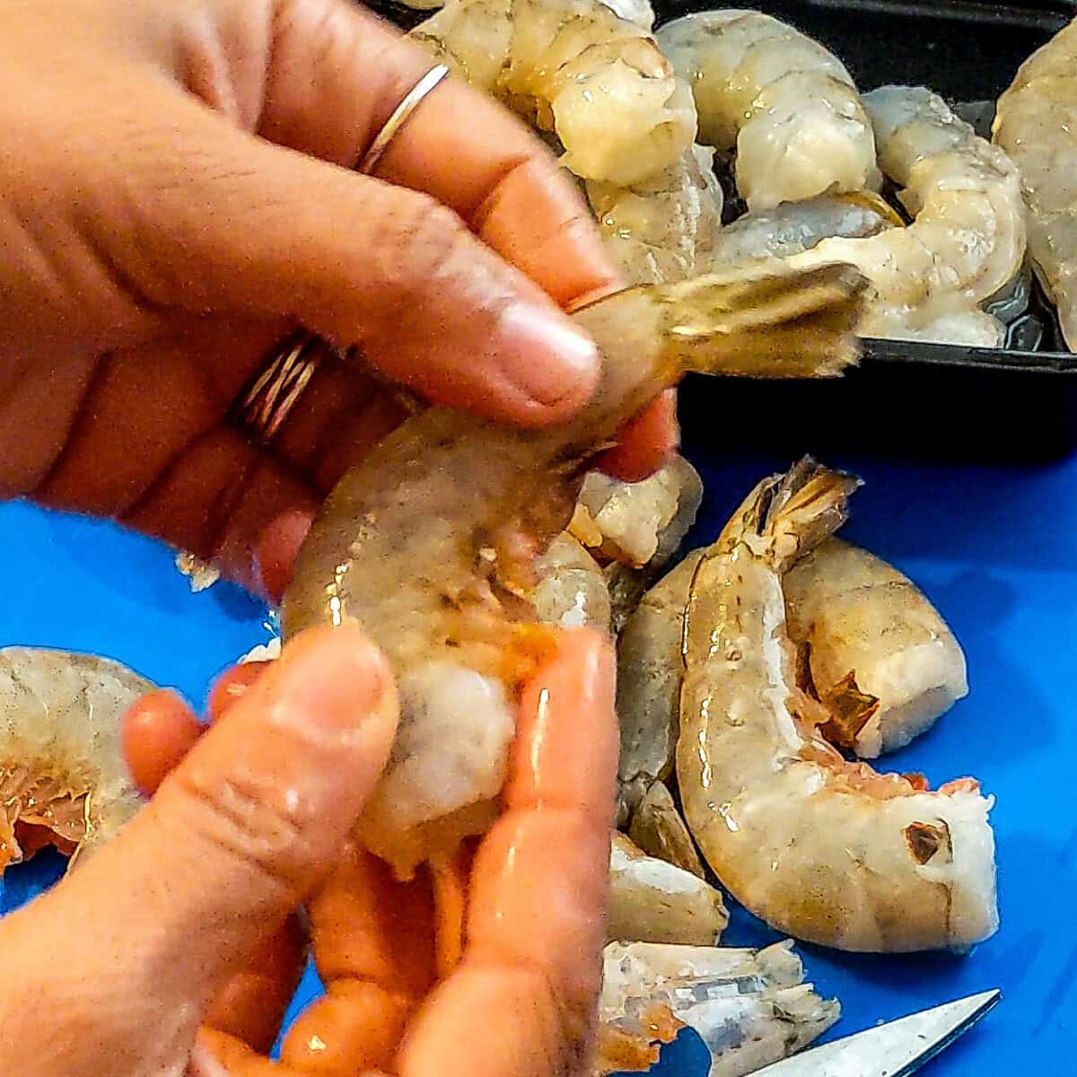 shrimp with shell on held in hand.