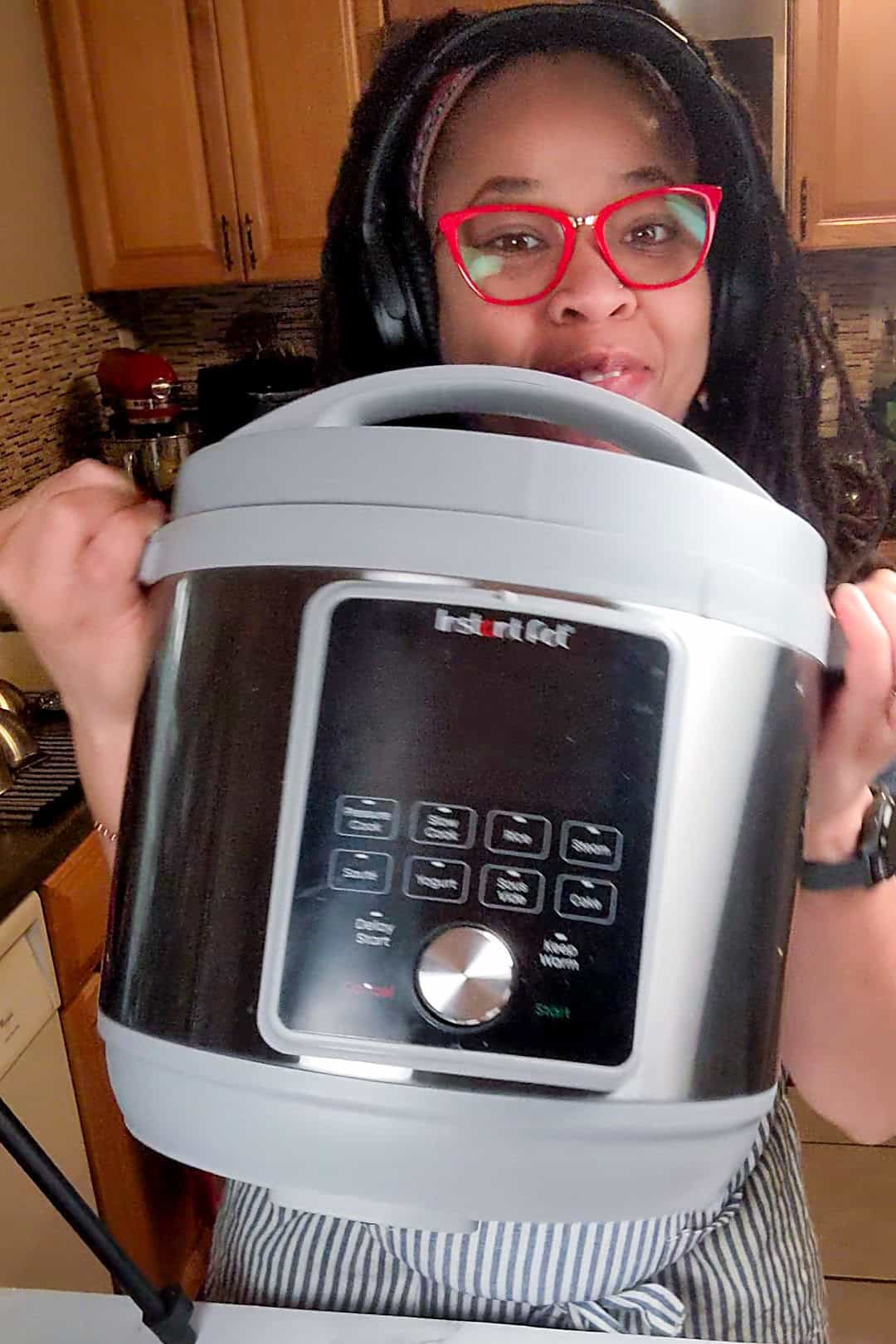 Chef Maika demonstrating an instant pot, a multi-cooker in a cozy kitchen, excited about cooking Spicy Beef Barley Stew.