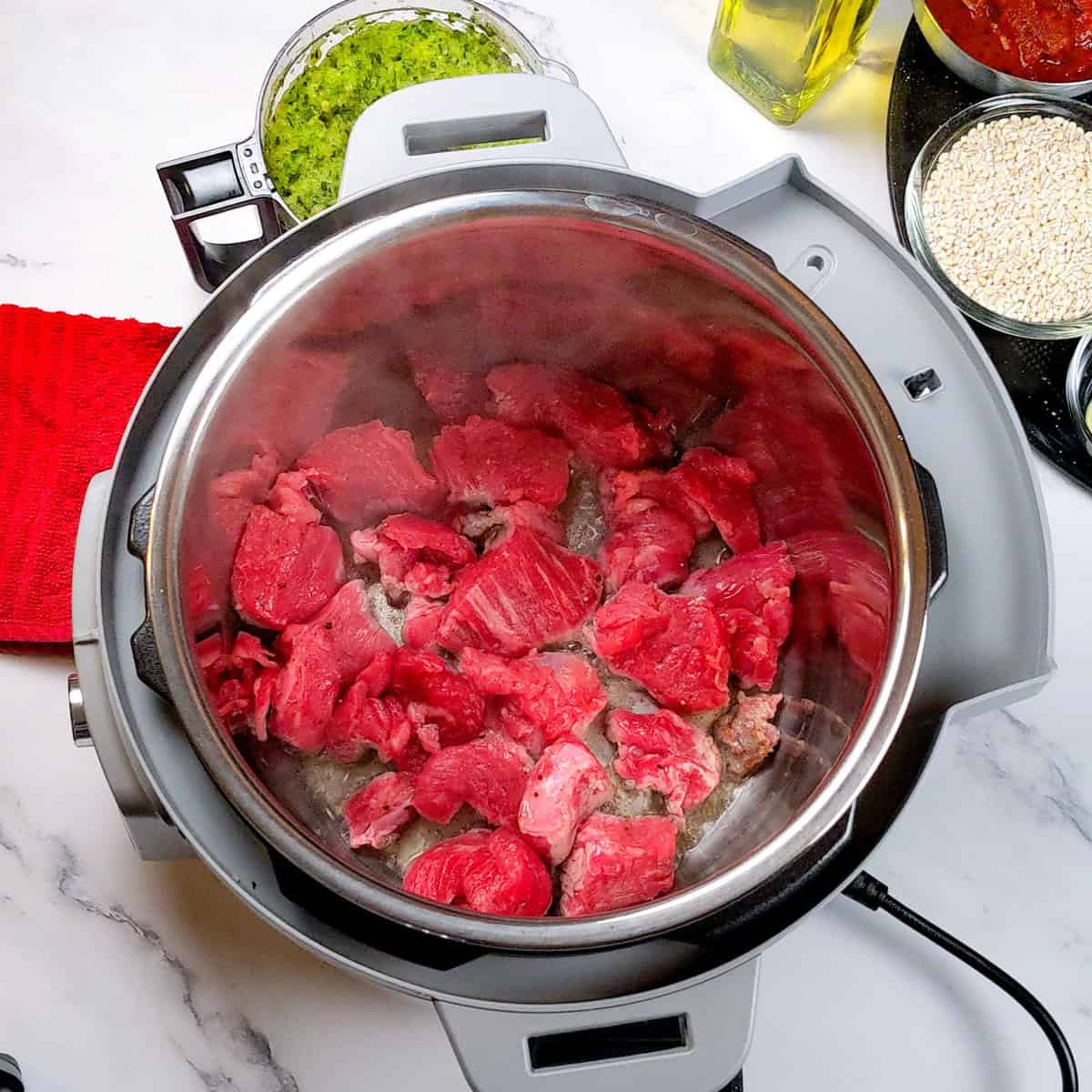 Searing tender beef in an Instant Pot for a hearty stew.