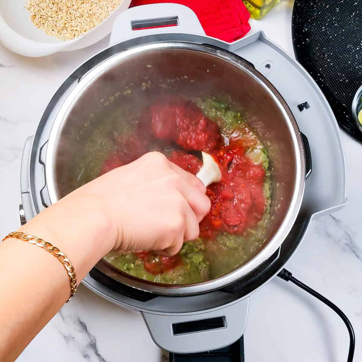 Cooking Spicy Beef Barley Stew with vibrant vegetables and tomato sauce in an Instant Pot.