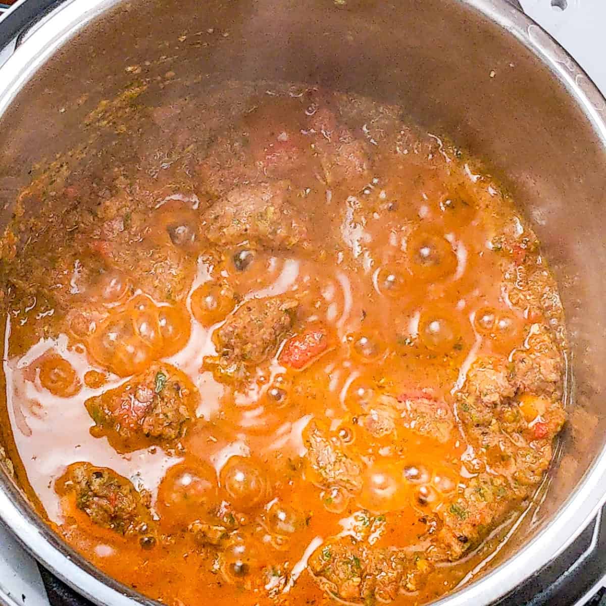 Vibrant spicy beef barley stew bubbling in a pot, showcasing rich flavors and warmth.