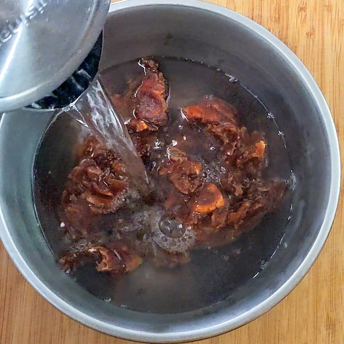 hot water from an electric tea kettle being poured over the pulp.