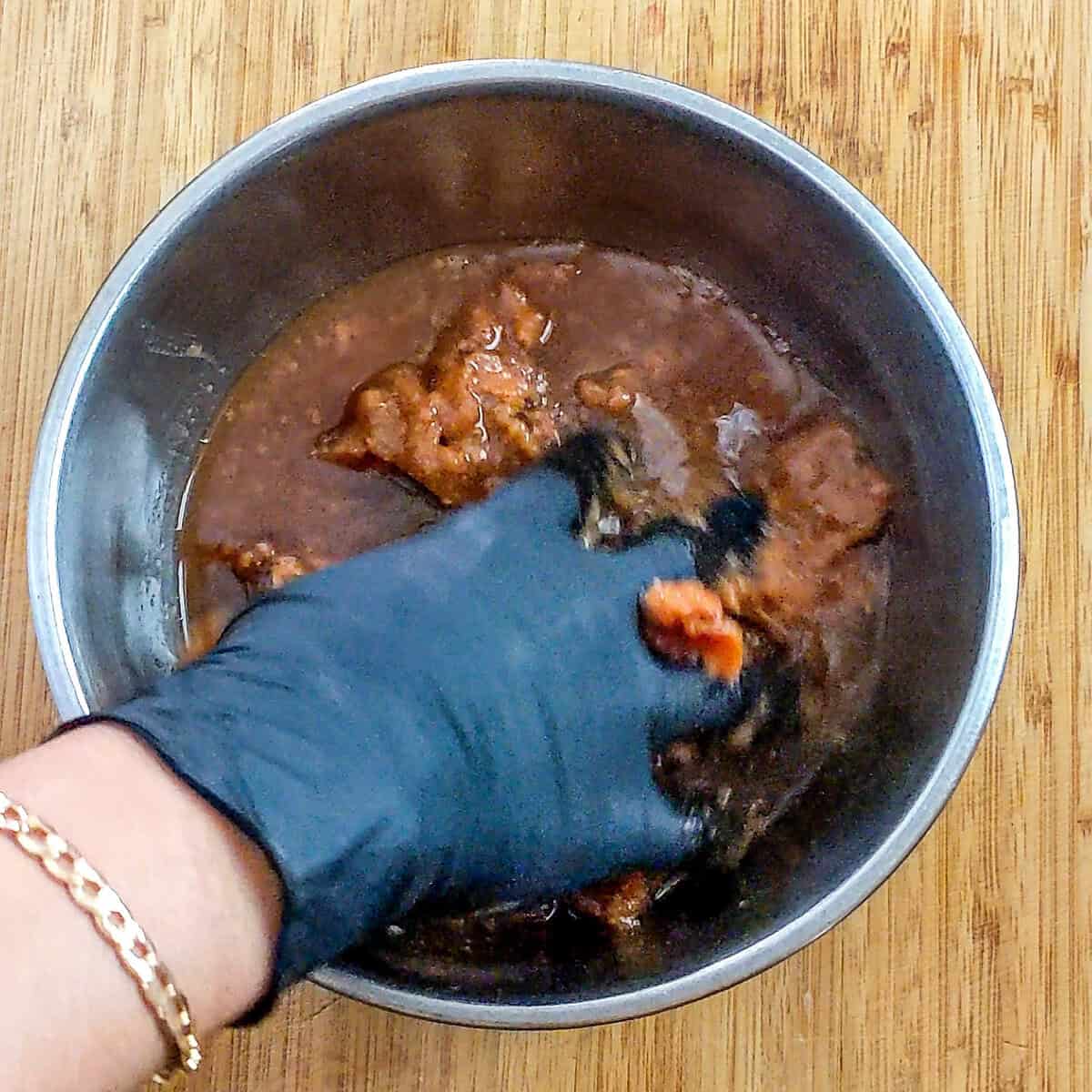 loose tamarind pulp being hand squeezed to incorporate the water.