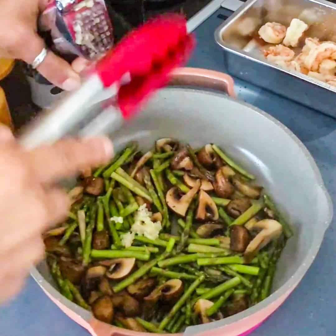 Sautéed asparagus and mushrooms with shrimp for delicious Argentinian shrimp pesto pasta.